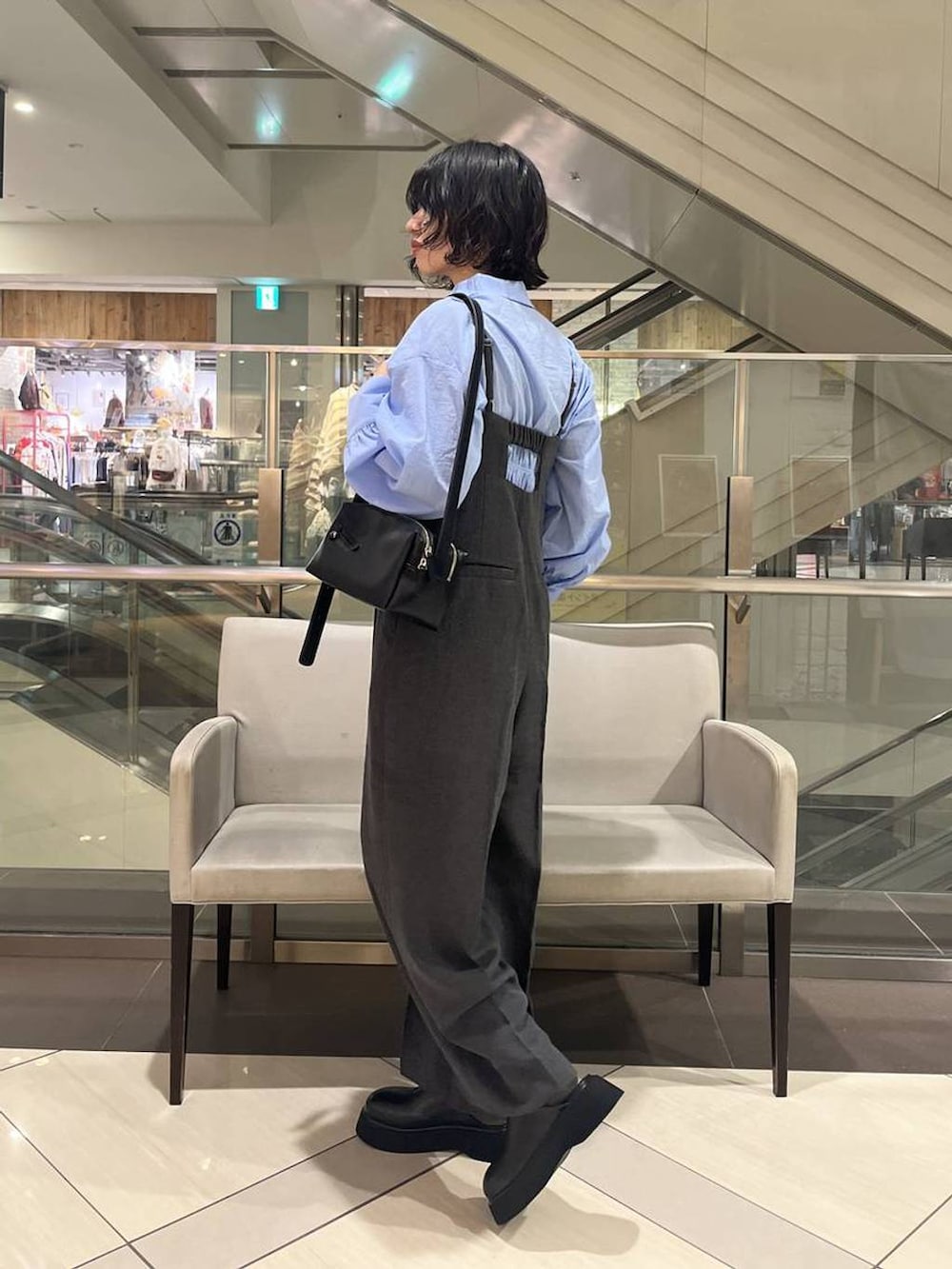 グレー系のサロペット/オーバーオール、ブラック系のショルダーバッグ、ブラック系のサンダルを着用したレディースの秋コーディネートの2枚目の写真
