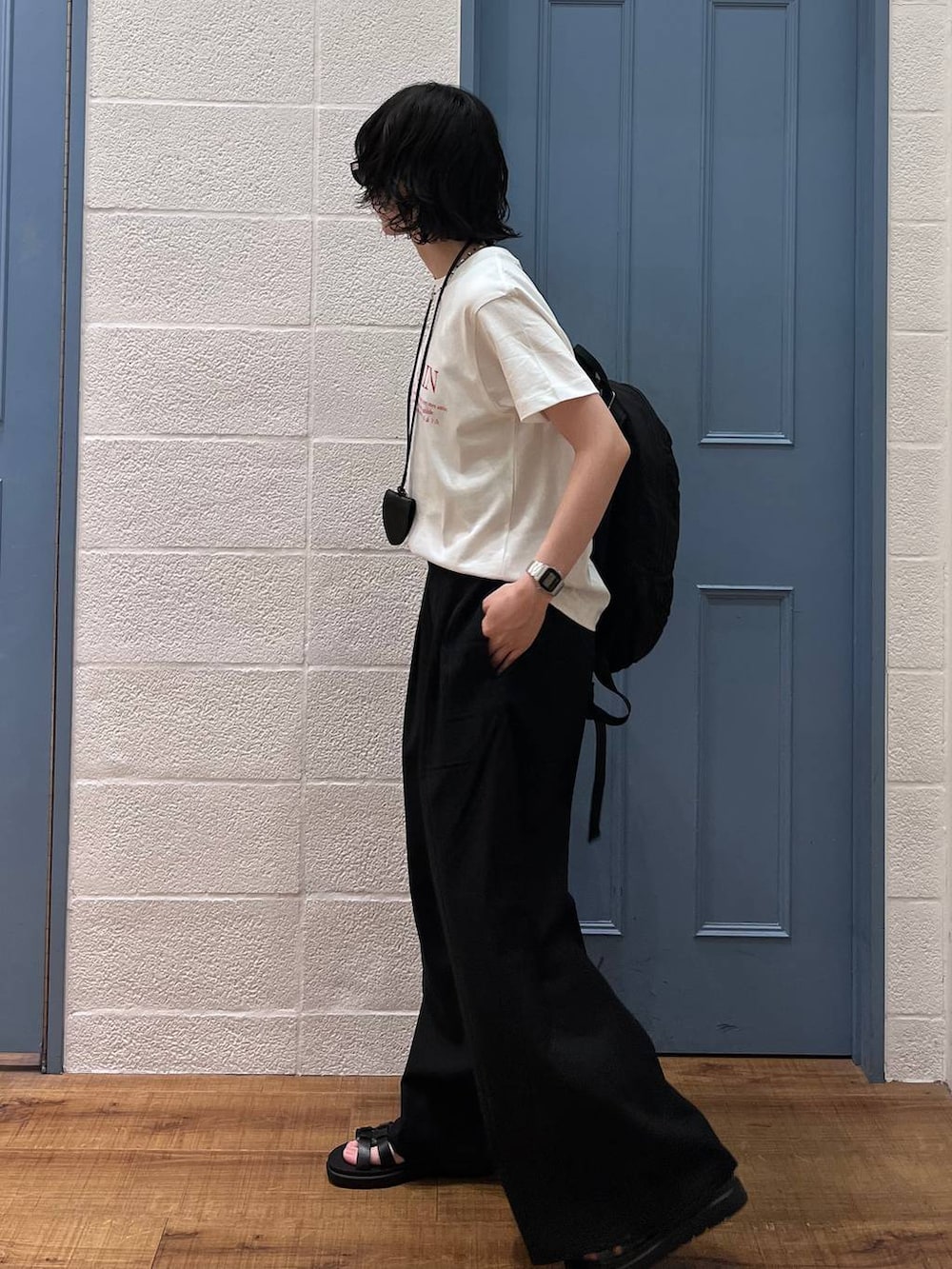 ブラック系のその他パンツ、ブラック系のサンダル、ホワイト系のTシャツ/カットソーを着用したレディースの春コーディネートの3枚目の写真