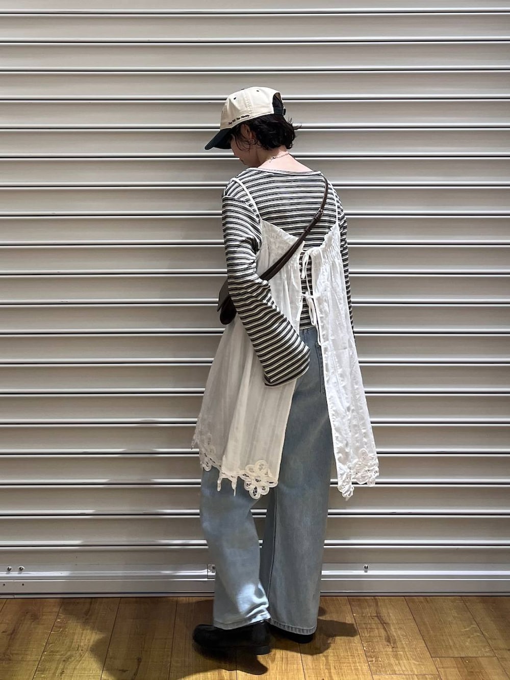 ブルー系のデニムパンツ、ブラック系のローファー、ブラウン系のボディバッグ/ウエストポーチを着用したレディースの春コーディネートの3枚目の写真