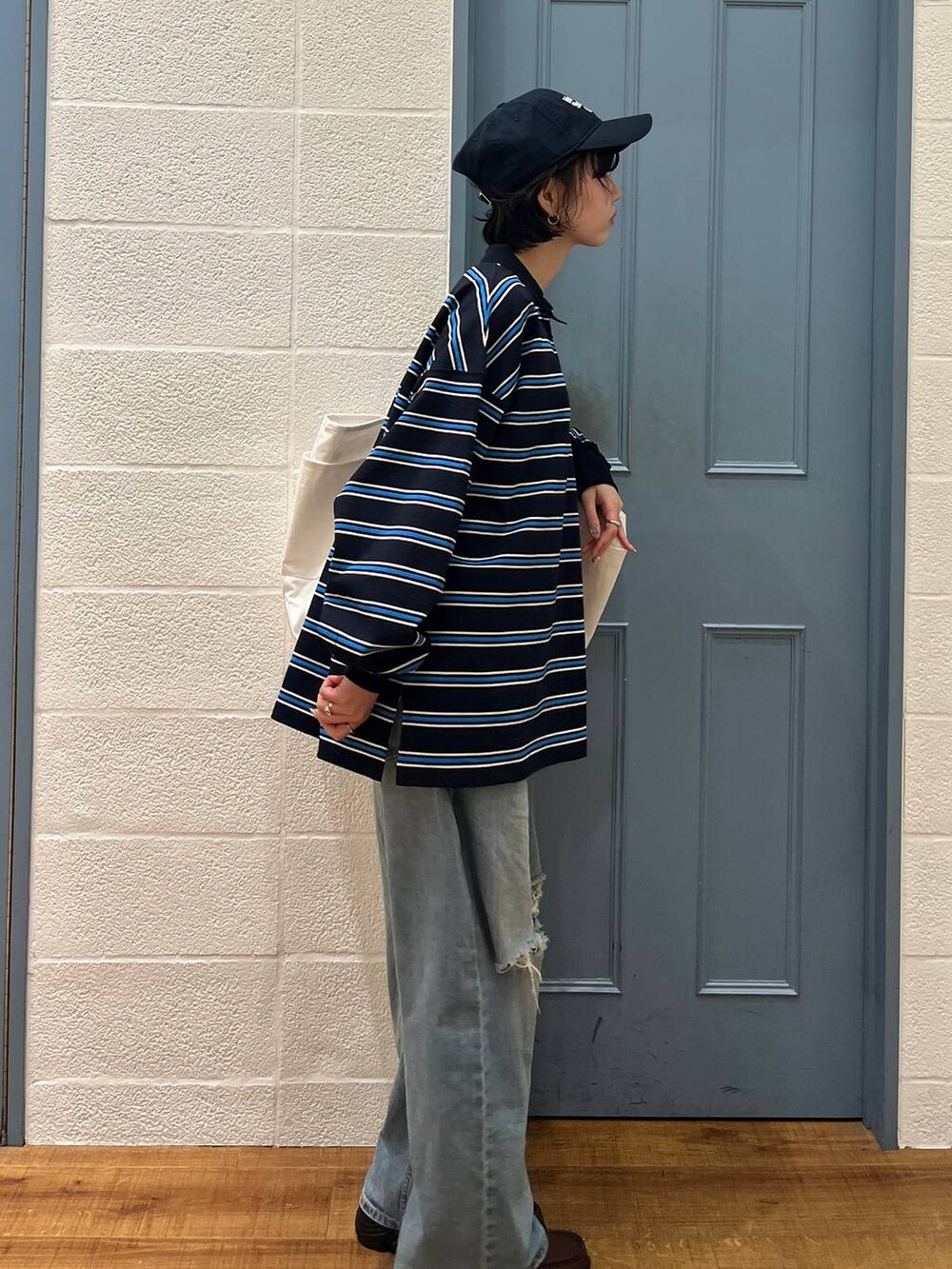 ブルー系のデニムパンツ、ブラウン系のローファー、ブルー系のTシャツ/カットソーを着用したレディースの春コーディネートの4枚目の写真