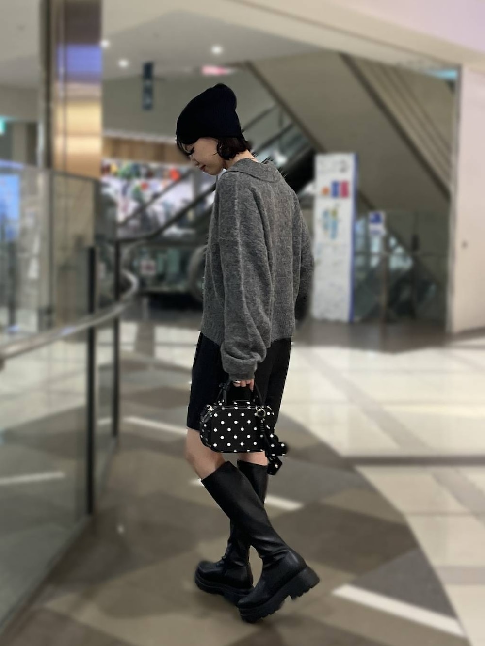 ブラック系のその他パンツ、ブラック系のブーツ、その他のボストンバッグを着用したレディースの秋コーディネートの2枚目の写真