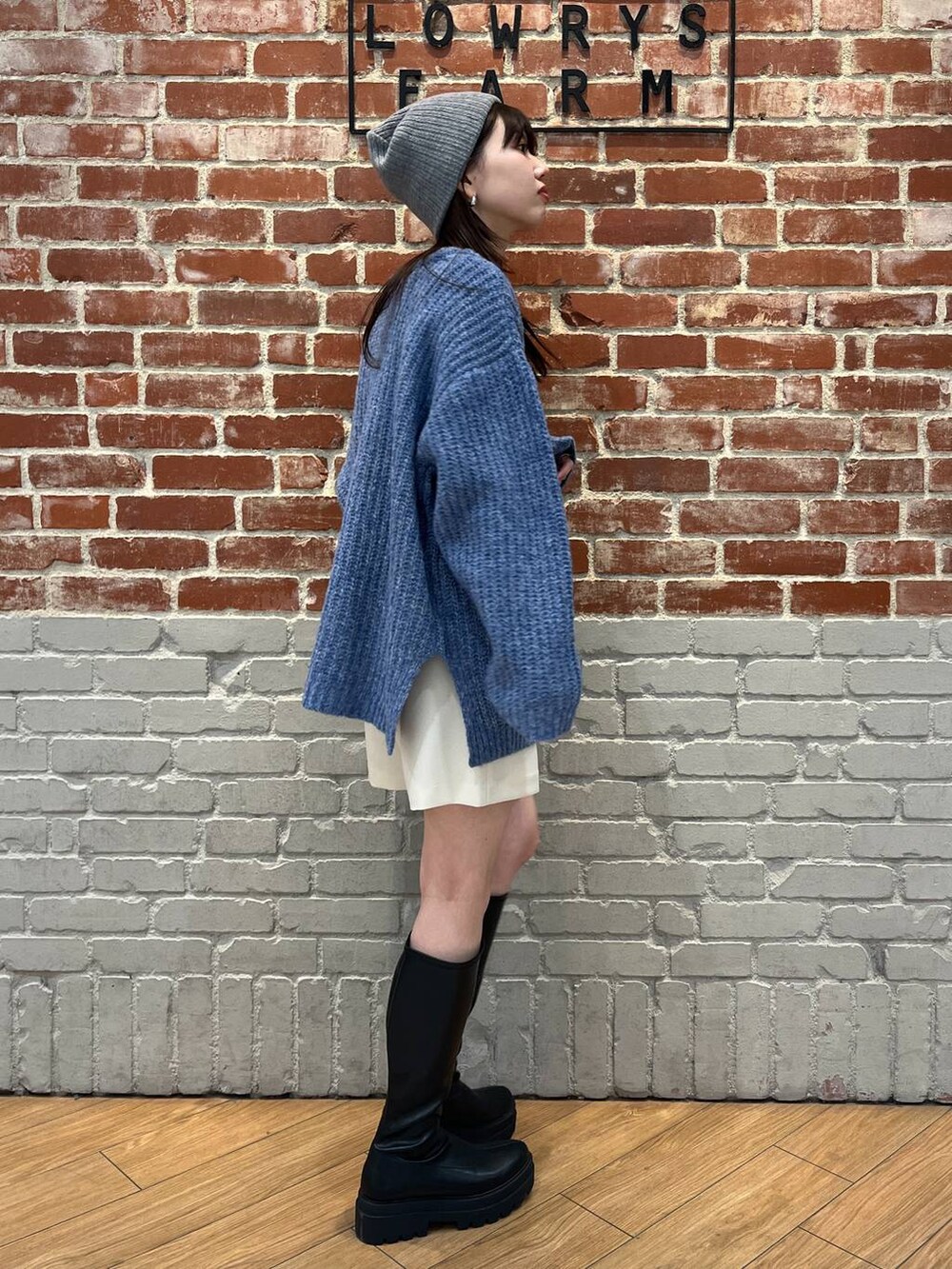 ホワイト系のTシャツ/カットソー、ブラック系のブーツ、ホワイト系のスカートを着用したレディースの冬コーディネートの3枚目の写真