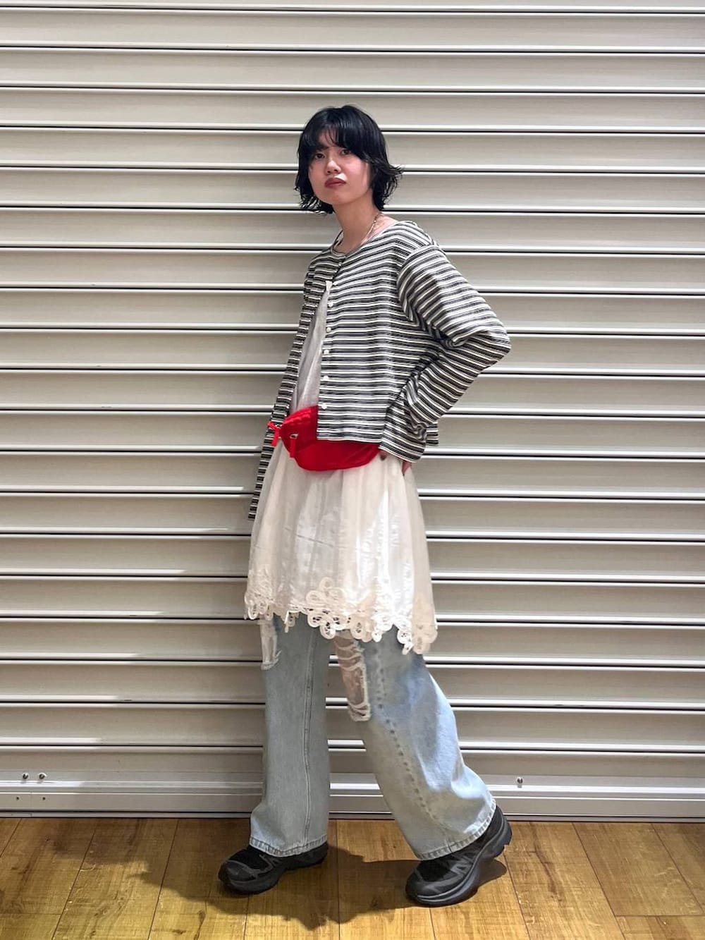 ブルー系のデニムパンツ、レッド系のボディバッグ/ウエストポーチ、ホワイト系のワンピースを着用したレディースの春コーディネートの4枚目の写真