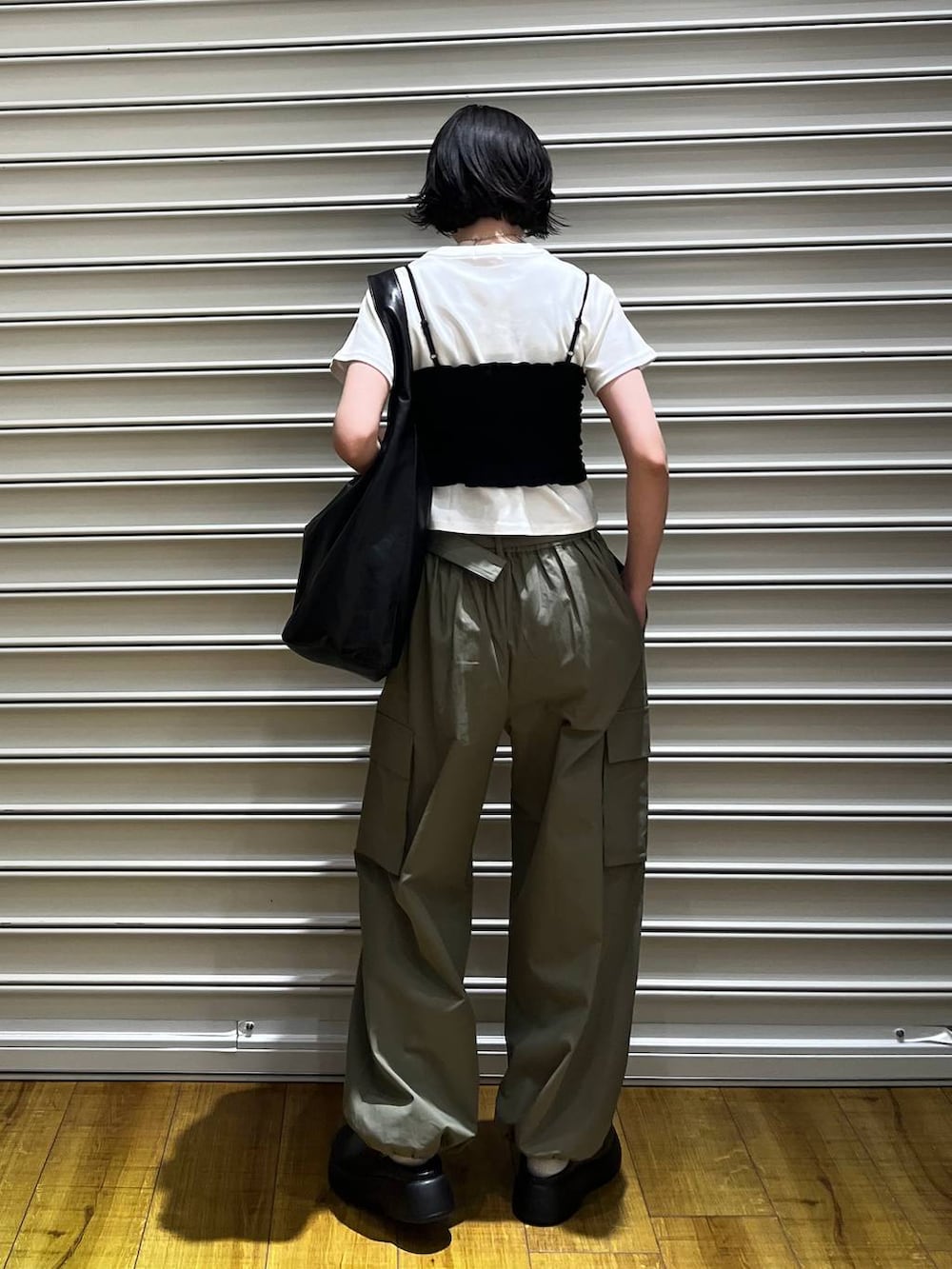 ブラック系のショルダーバッグ、ブラック系のサンダル、ホワイト系のTシャツ/カットソーを着用したレディースの春コーディネートの2枚目の写真