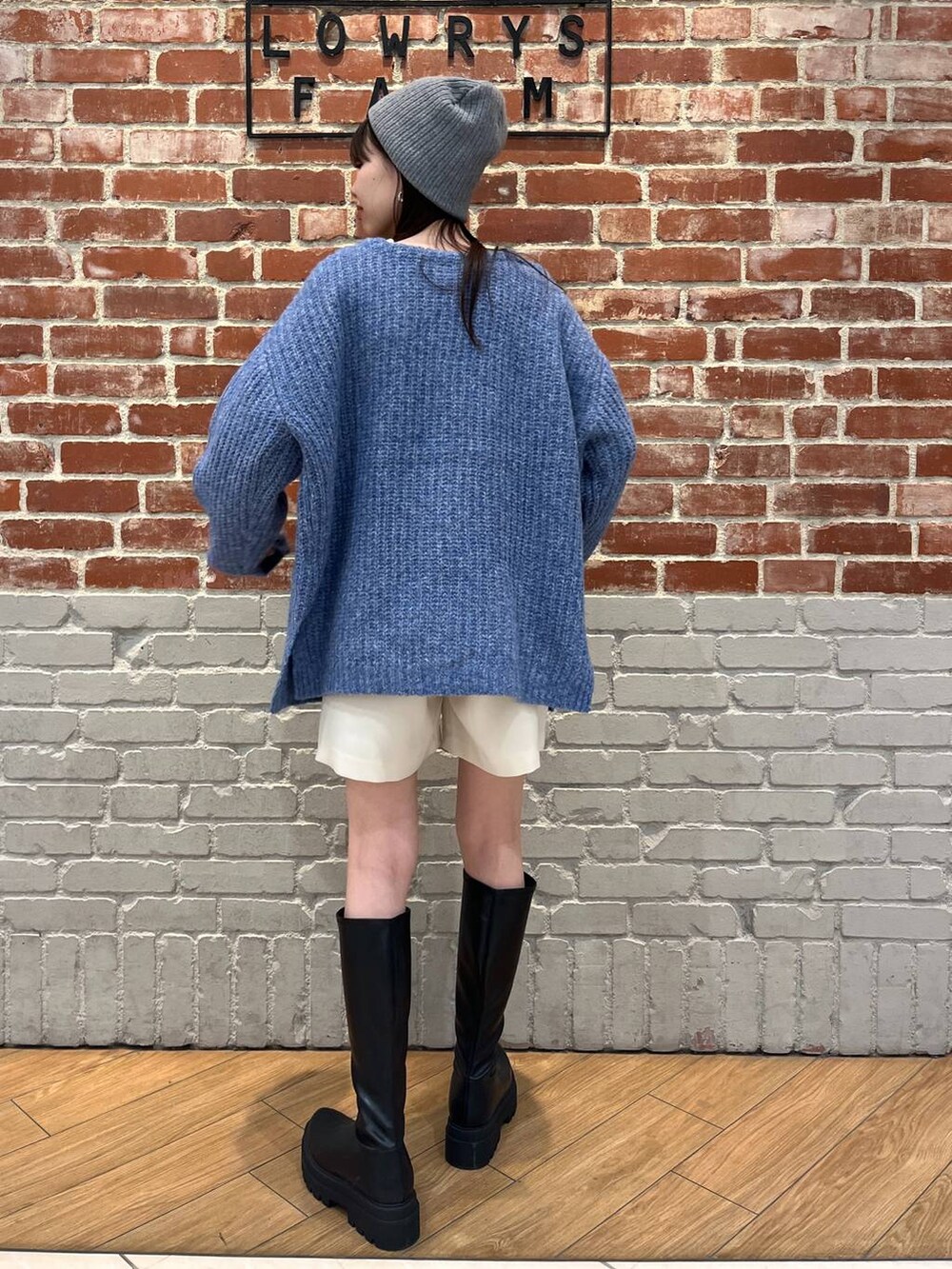 ホワイト系のTシャツ/カットソー、ブラック系のブーツ、ホワイト系のスカートを着用したレディースの冬コーディネートの2枚目の写真