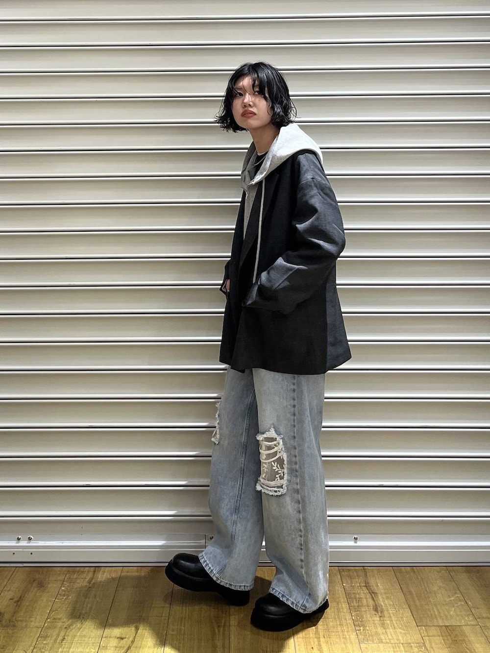 ブルー系のニット/セーター、ブラック系のサンダル、グレー系のパーカーを着用したレディースの冬コーディネートの2枚目の写真