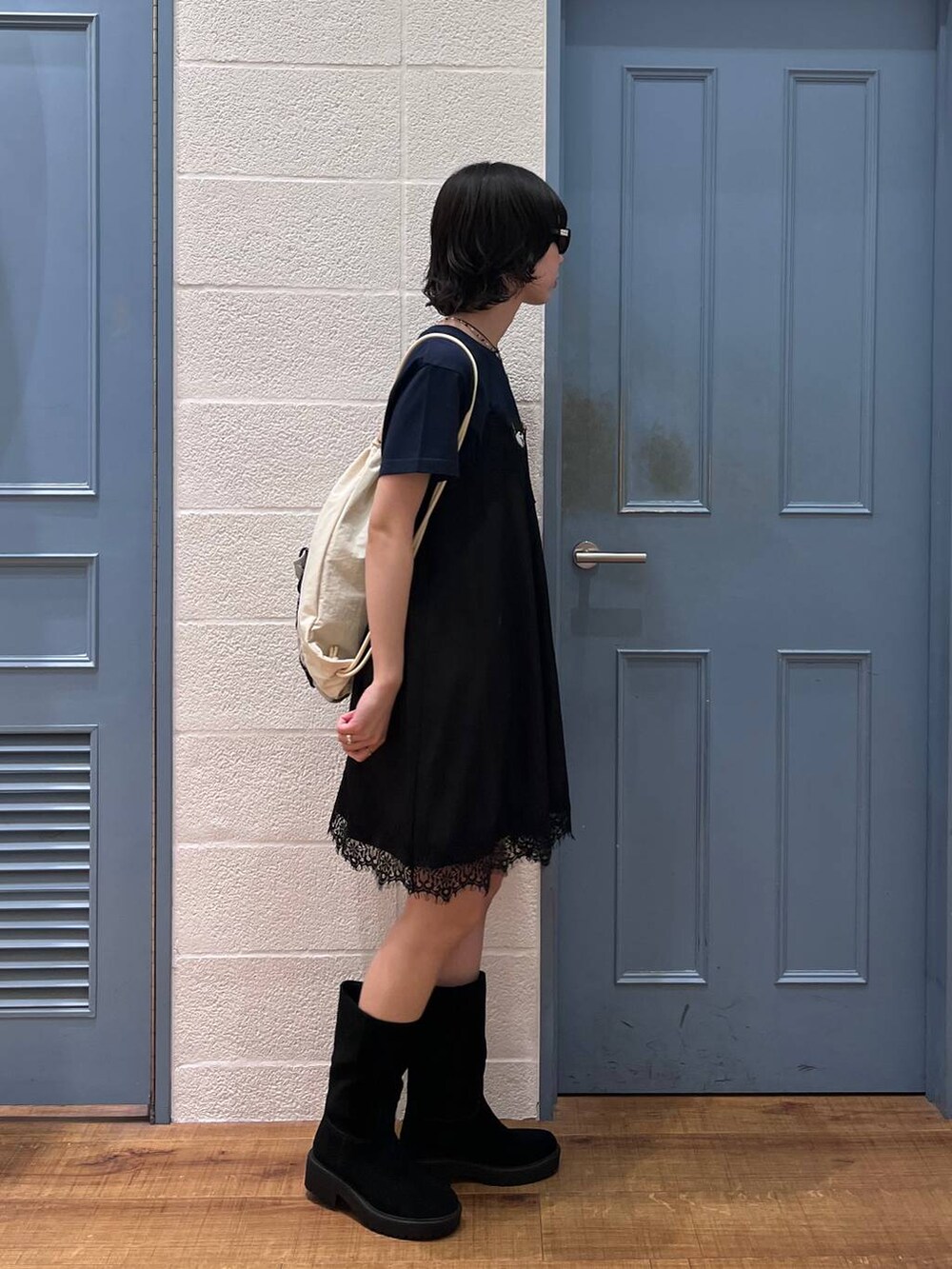 ブラック系のブーツ、ブルー系のTシャツ/カットソー、ホワイト系のバックパック/リュックを着用したレディースの春コーディネートの2枚目の写真