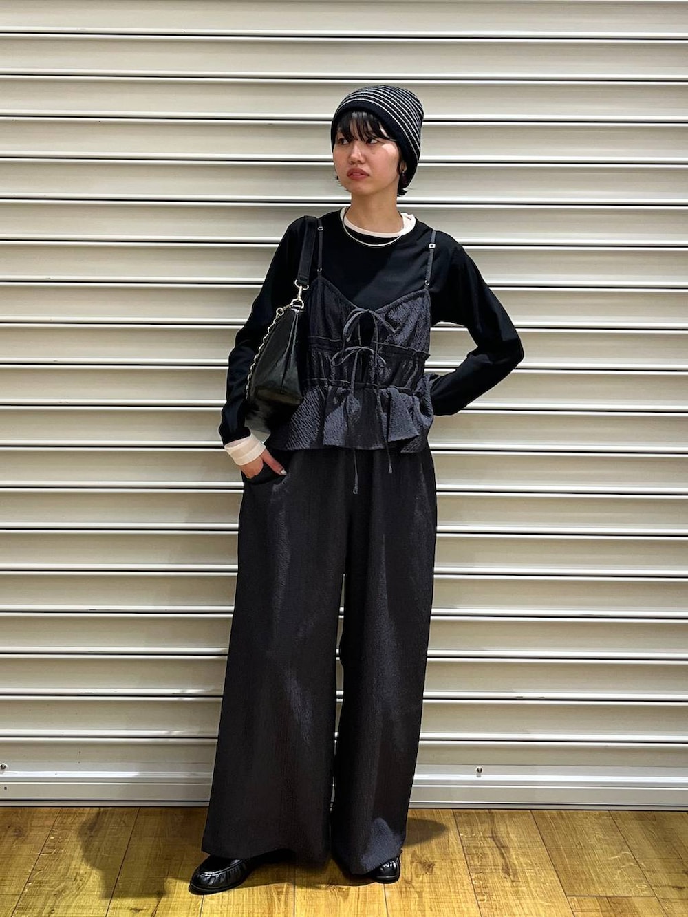 ブラック系のショルダーバッグ、ブラック系のローファー、ブラック系のTシャツ/カットソーを着用したレディースの春コーディネートの2枚目の写真