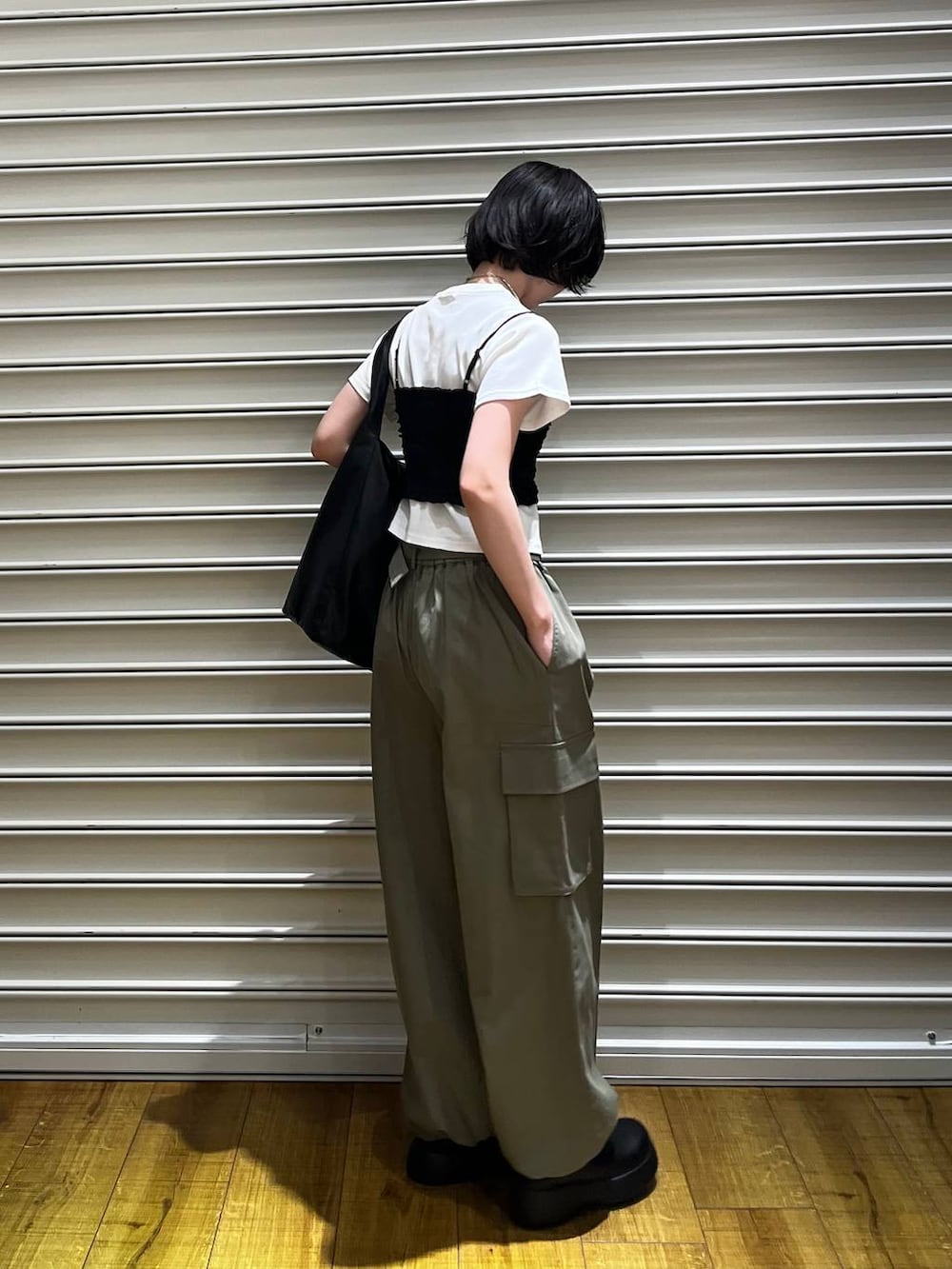 ブラック系のショルダーバッグ、ブラック系のサンダル、ホワイト系のTシャツ/カットソーを着用したレディースの春コーディネートの4枚目の写真