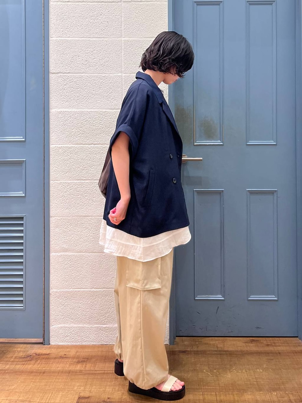 ブラウン系のショルダーバッグ、グレー系のTシャツ/カットソー、ブルー系のテーラードジャケットを着用したレディースの春コーディネートの2枚目の写真