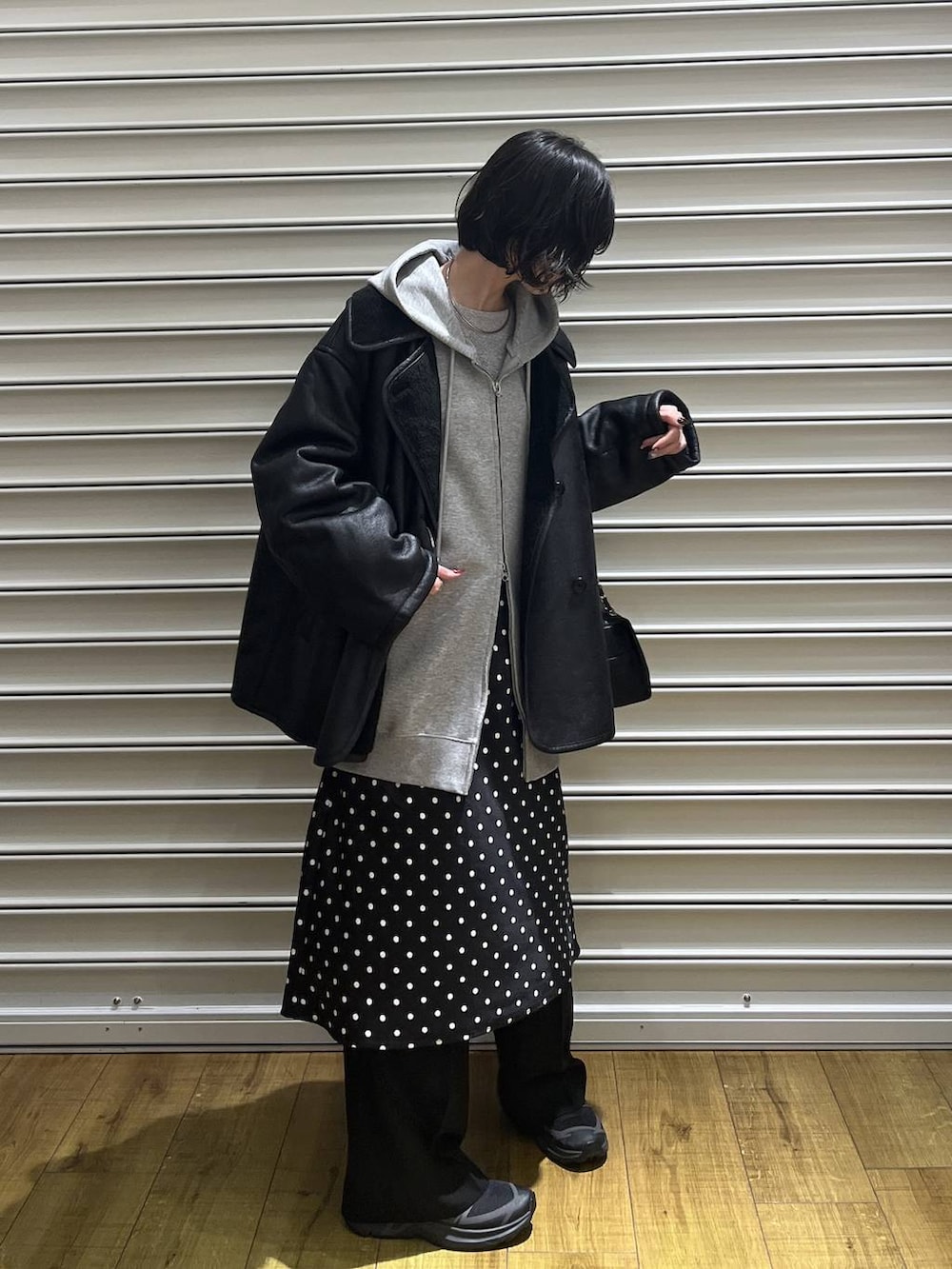 ブラック系のスカート、グレー系のパーカー、ブラック系のその他パンツを着用したレディースの冬コーディネートの3枚目の写真