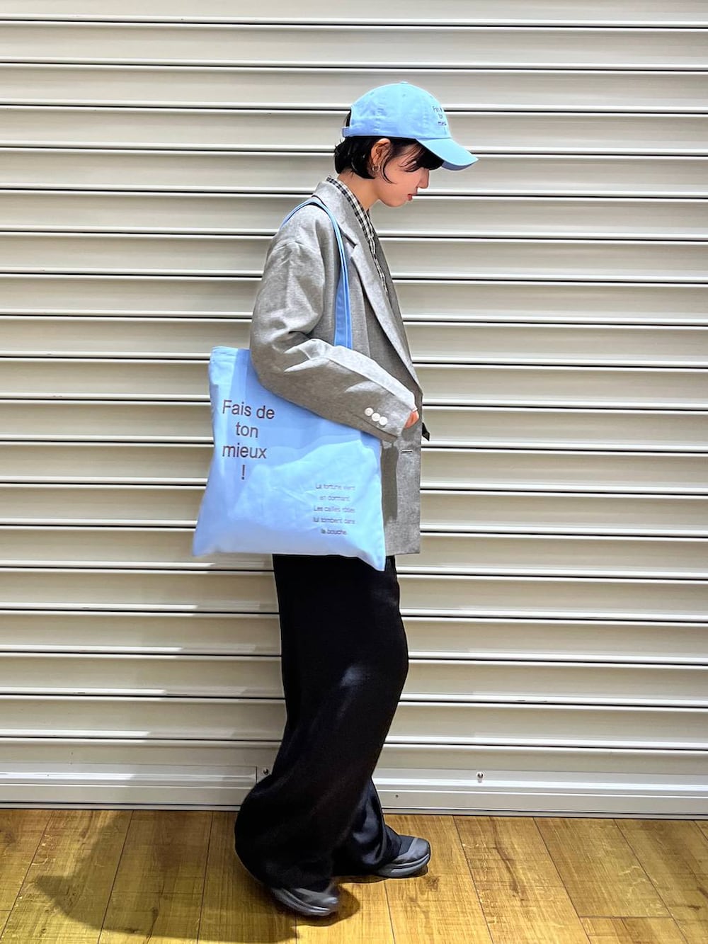 ブラック系のその他パンツ、グレー系のテーラードジャケット、ブルー系のトートバッグを着用したレディースの春コーディネートの3枚目の写真