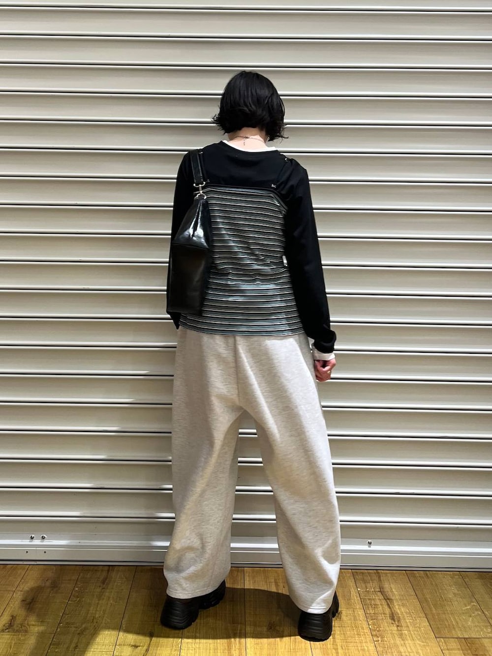 グレー系のスウェットパンツ、ブラウン系のローファー、グリーン系のカーディガン/ボレロを着用したレディースの春コーディネートの3枚目の写真