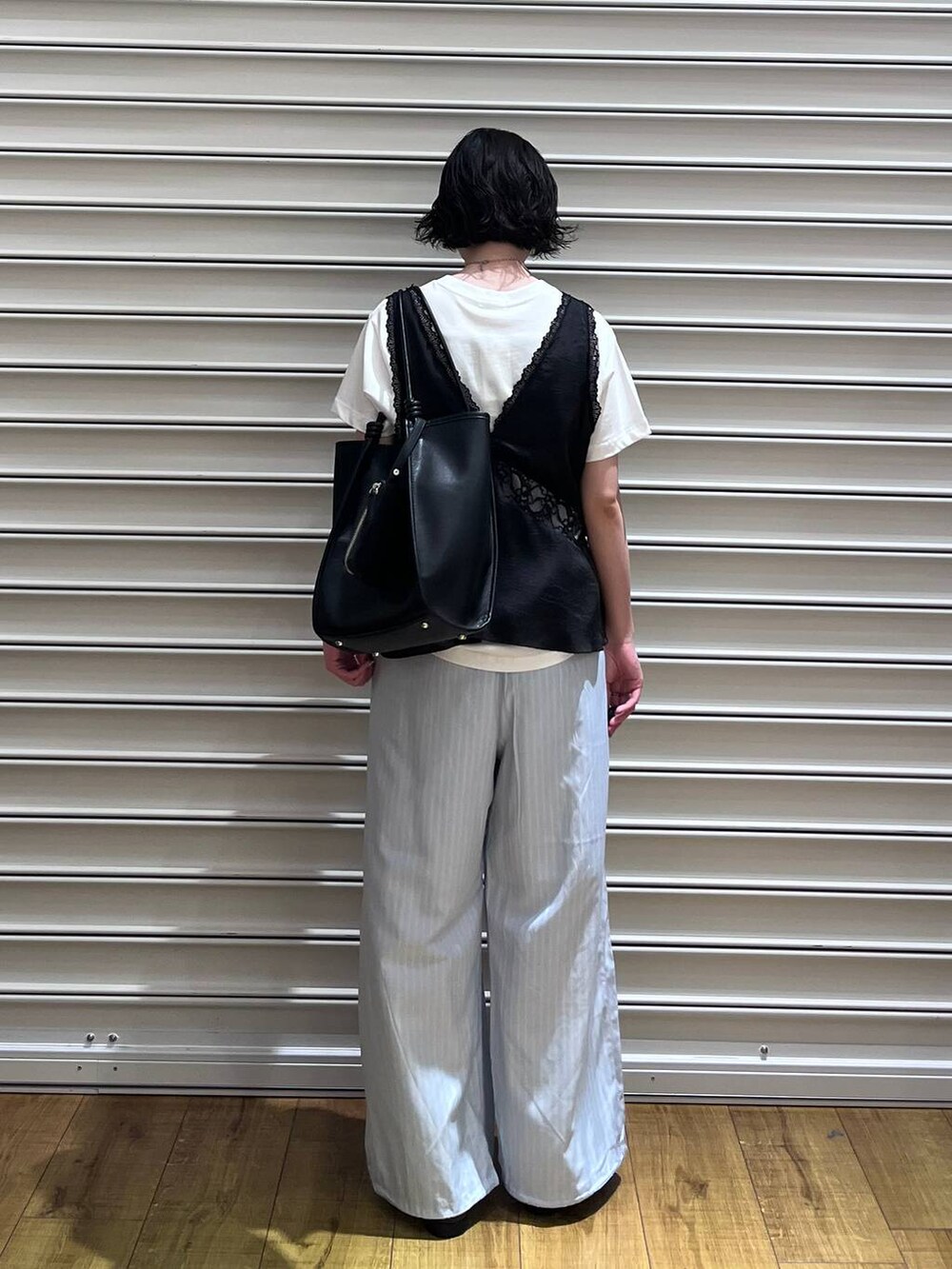 ブラック系のローファー、ホワイト系のTシャツ/カットソー、ブラック系のベストを着用したレディースの春コーディネートの3枚目の写真