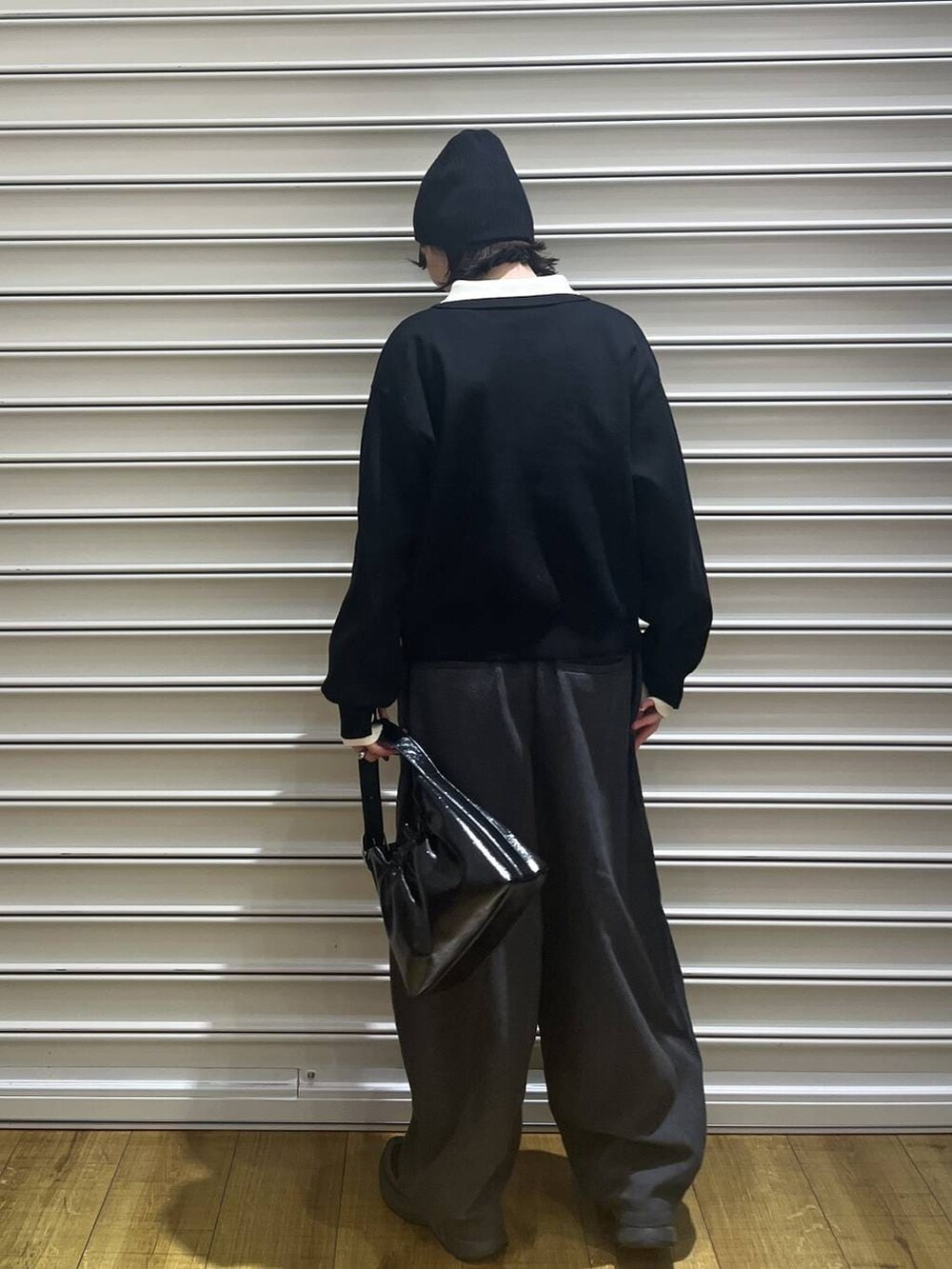 ブラック系のショルダーバッグ、ブラック系のニット/セーター、ブラック系のニットキャップ/ビーニーを着用したレディースの冬コーディネートの4枚目の写真