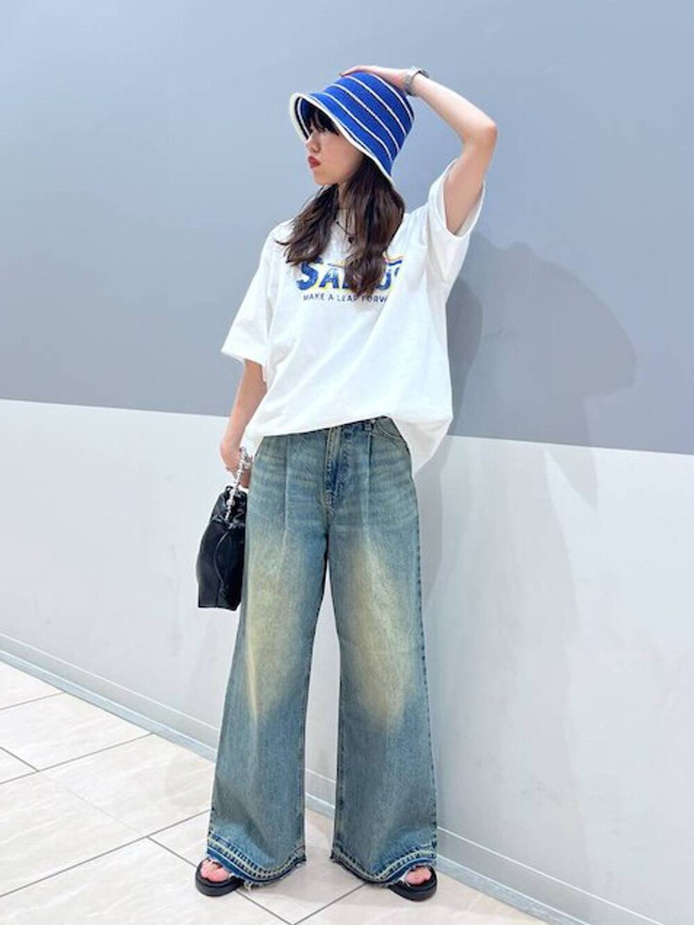 ホワイト系のTシャツ/カットソー、シルバー系のスニーカー、ブラック系のショルダーバッグを着用したレディースの夏コーディネートの2枚目の写真
