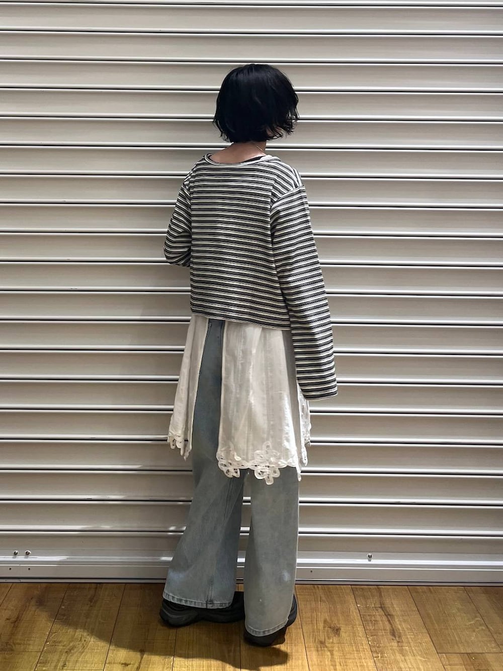 ブルー系のデニムパンツ、レッド系のボディバッグ/ウエストポーチ、ホワイト系のワンピースを着用したレディースの春コーディネートの3枚目の写真