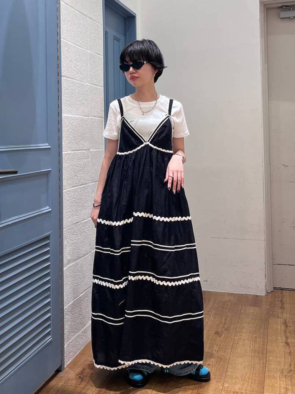 ホワイト系のTシャツ/カットソー、ブルー系のデニムパンツ、ブラック系のワンピースを着用したレディースの夏コーディネートの2枚目の写真