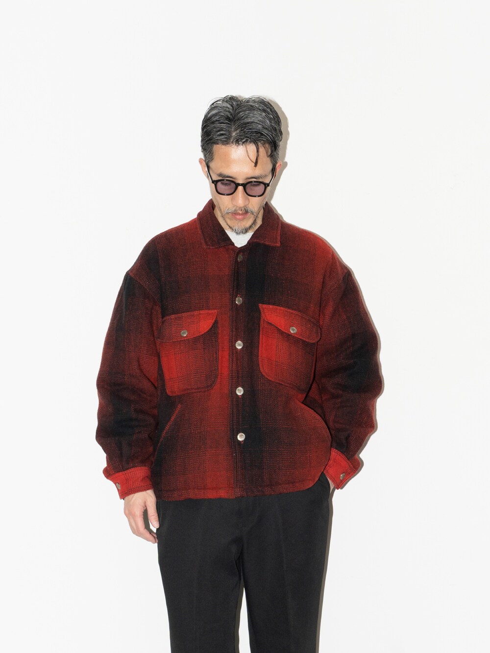 レッド系のジャケット/アウター、ブラック系のスラックス、ブラック系のスニーカーを着用したメンズの冬コーディネートの2枚目の写真