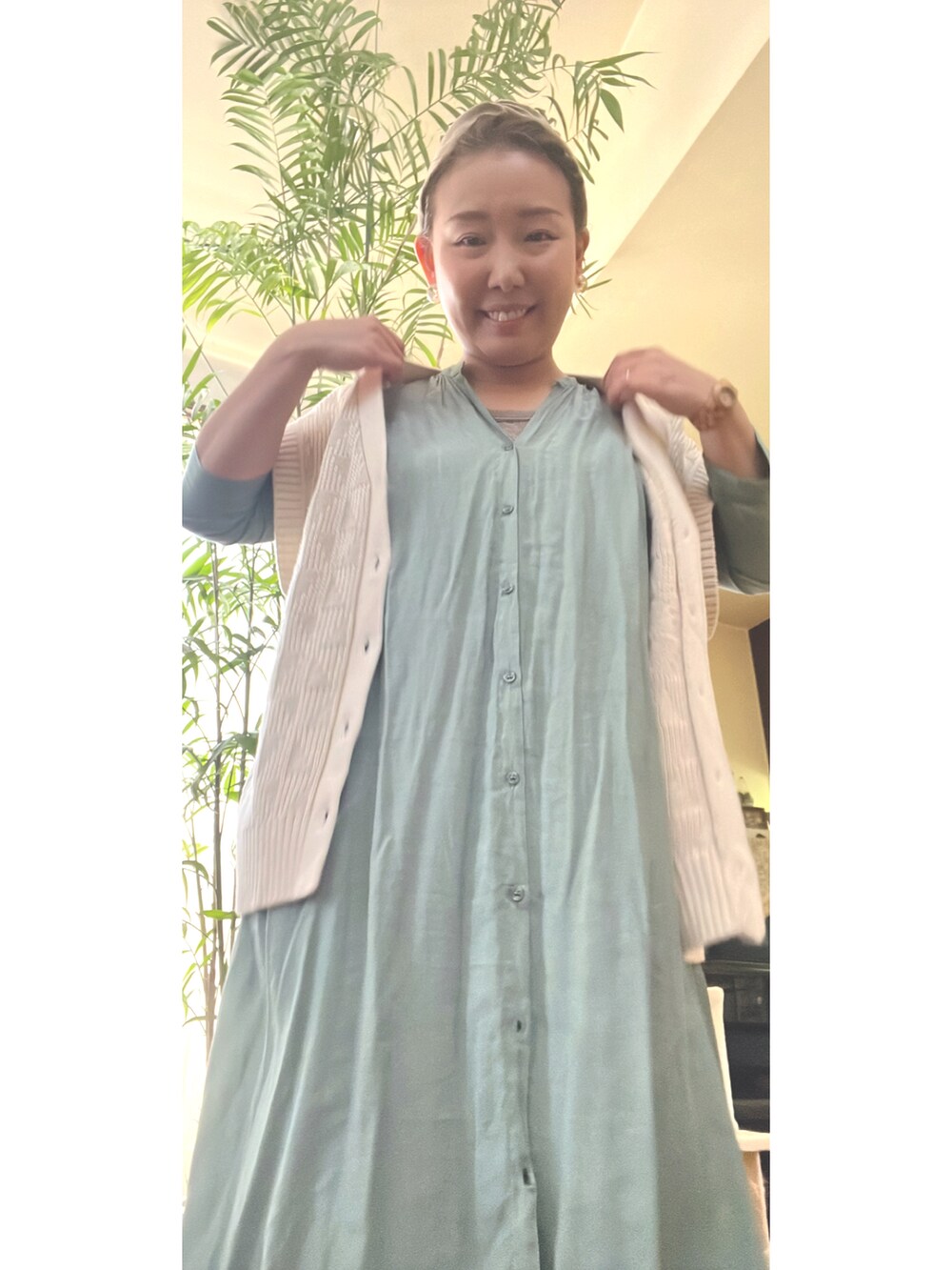 グリーン系のシャツワンピース、ホワイト系のベスト、その他の腕時計を着用したレディースの春コーディネートの2枚目の写真