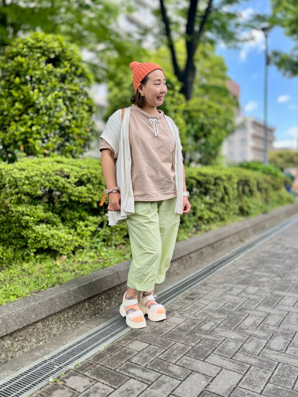 イエロー系のその他パンツ、イエロー系のバックパック/リュック、ベージュ系のTシャツ/カットソーを着用したレディースの春コーディネートの2枚目の写真