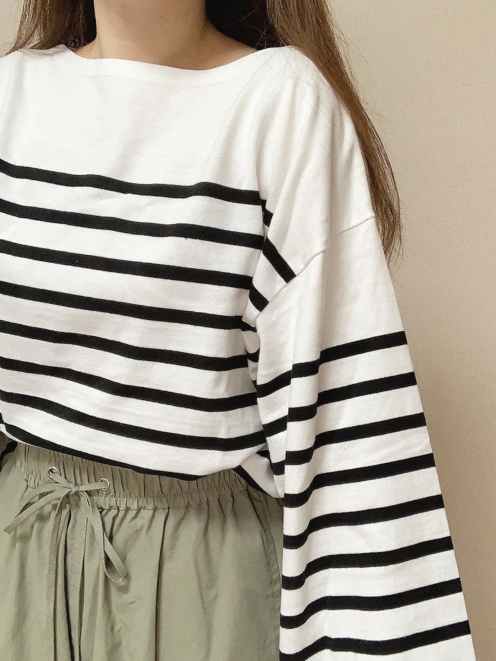 グリーン系のカーゴパンツ、ホワイト系のTシャツ/カットソーを着用したレディースの秋コーディネートの3枚目の写真