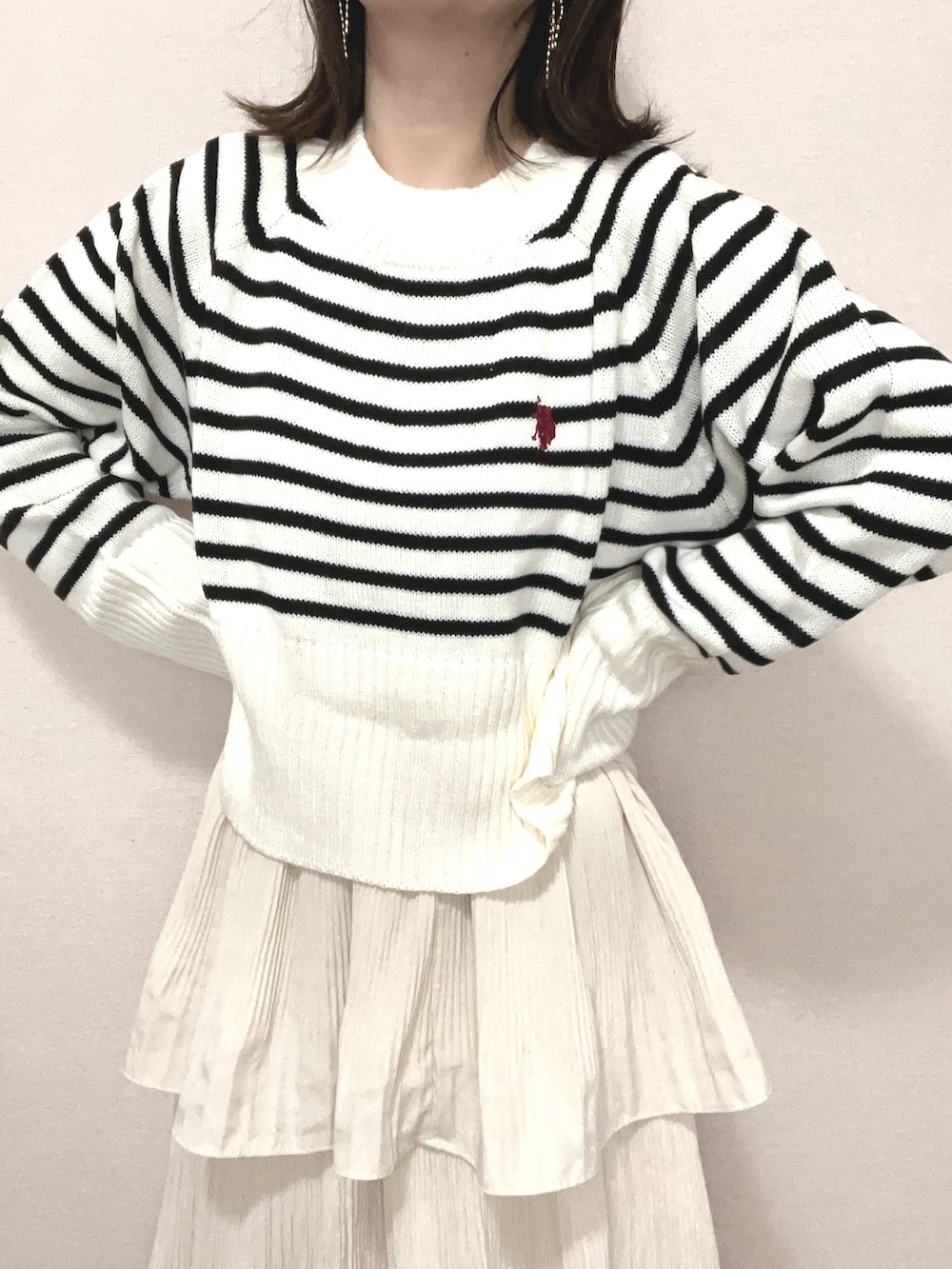 ホワイト系のニット/セーター、ベージュ系のスカート、ブラック系のブーツを着用したレディースの冬コーディネートの3枚目の写真