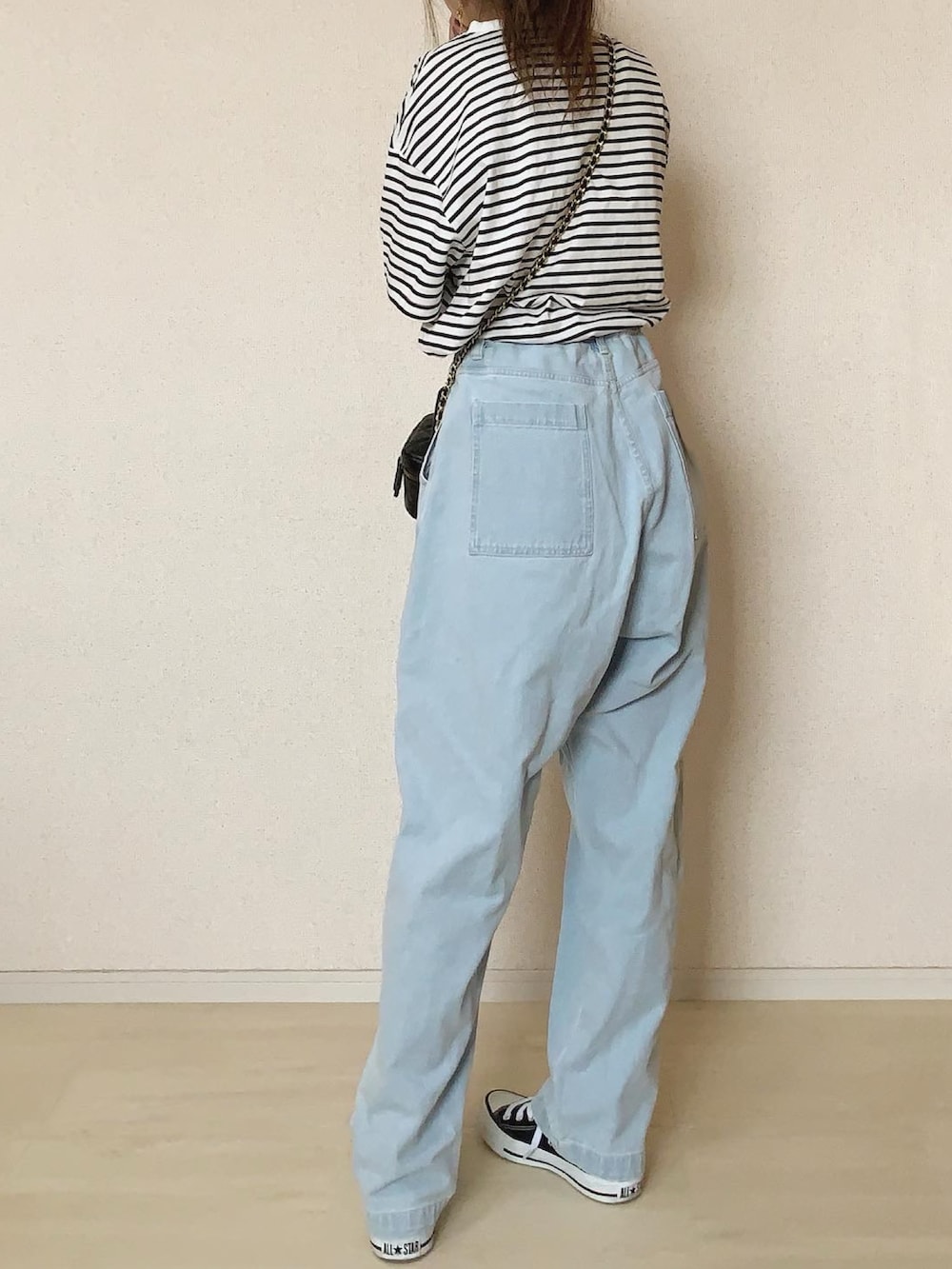ブルー系のデニムパンツ、ホワイト系のTシャツ/カットソー、ブラック系のスニーカーを着用したレディースの春コーディネートの3枚目の写真