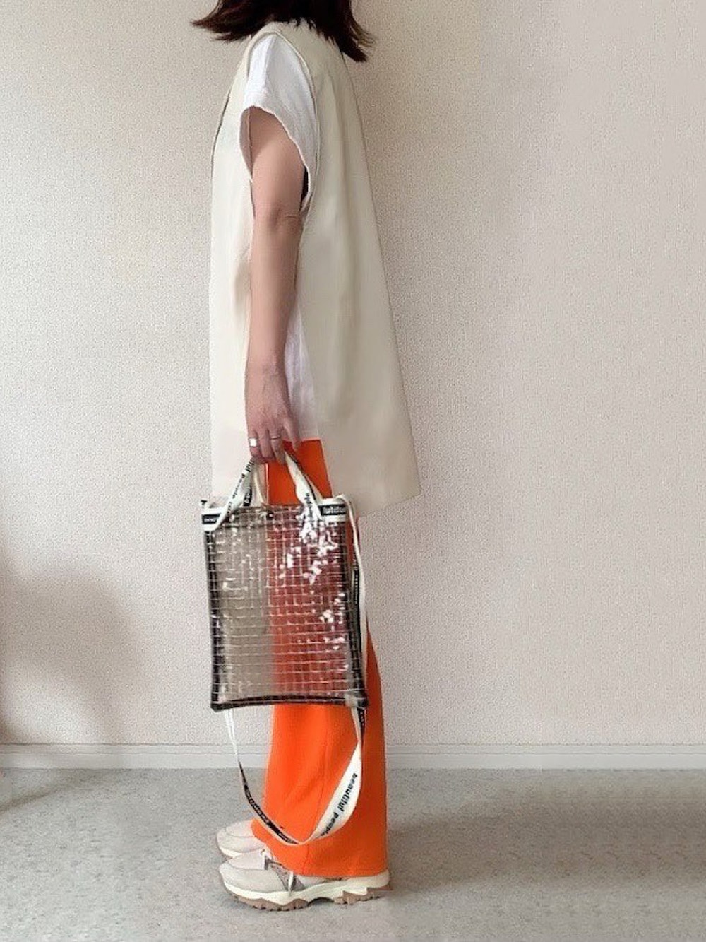 ブラック系のショルダーバッグ、その他のスニーカー、オレンジ系のパンツを着用したレディースの夏コーディネートの2枚目の写真