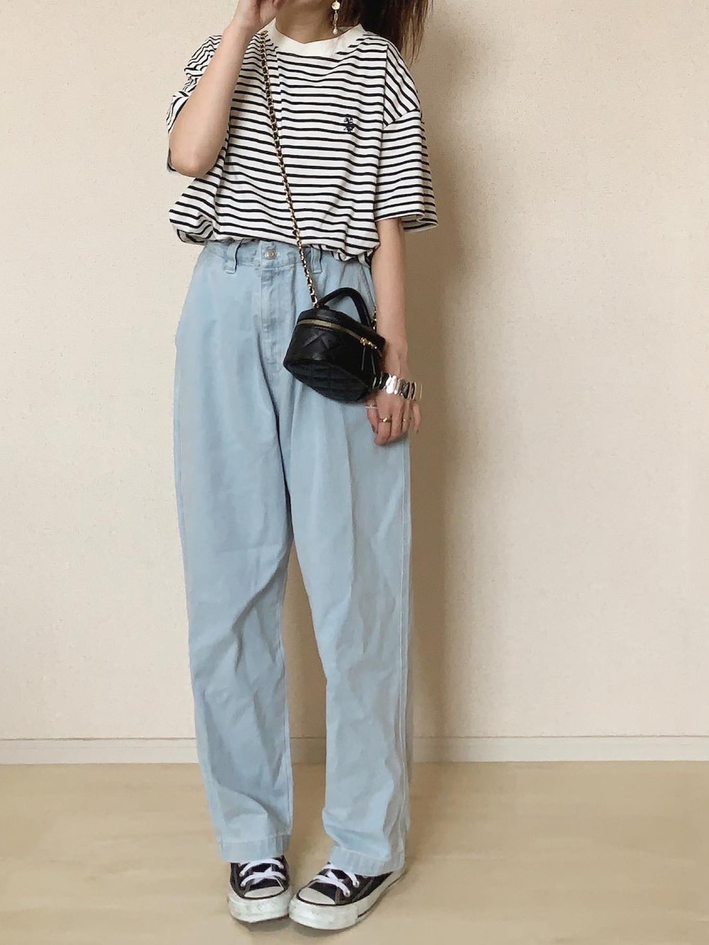 ブルー系のデニムパンツ、ホワイト系のTシャツ/カットソー、ブラック系のスニーカーを着用したレディースの春コーディネートの2枚目の写真