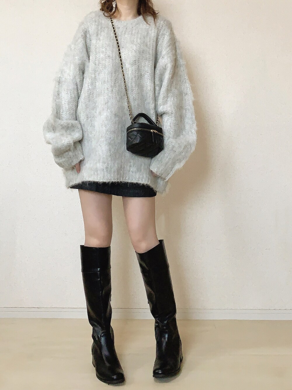 グレー系のニット/セーター、ブラック系のスカートを着用したレディースの冬コーディネートの2枚目の写真