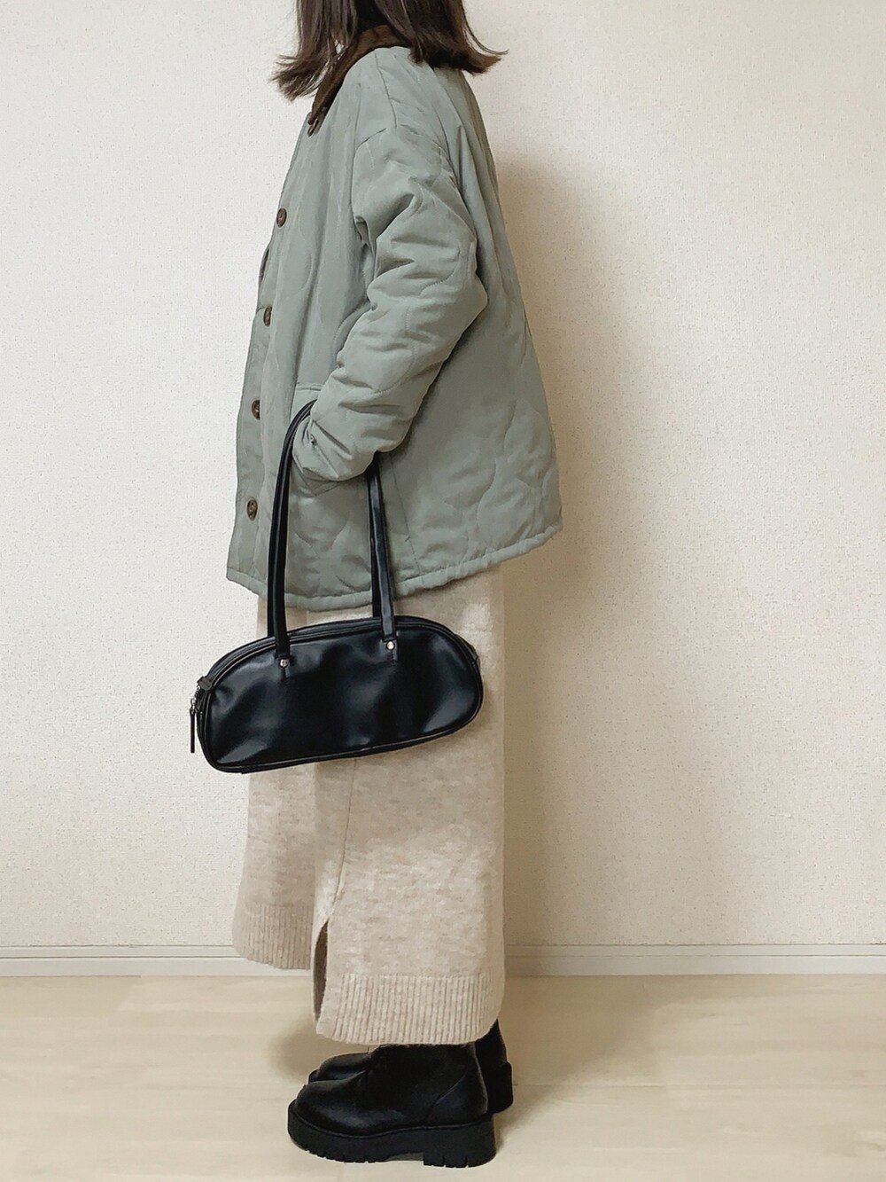 グリーン系のブルゾンを着用したレディースの冬コーディネートの2枚目の写真