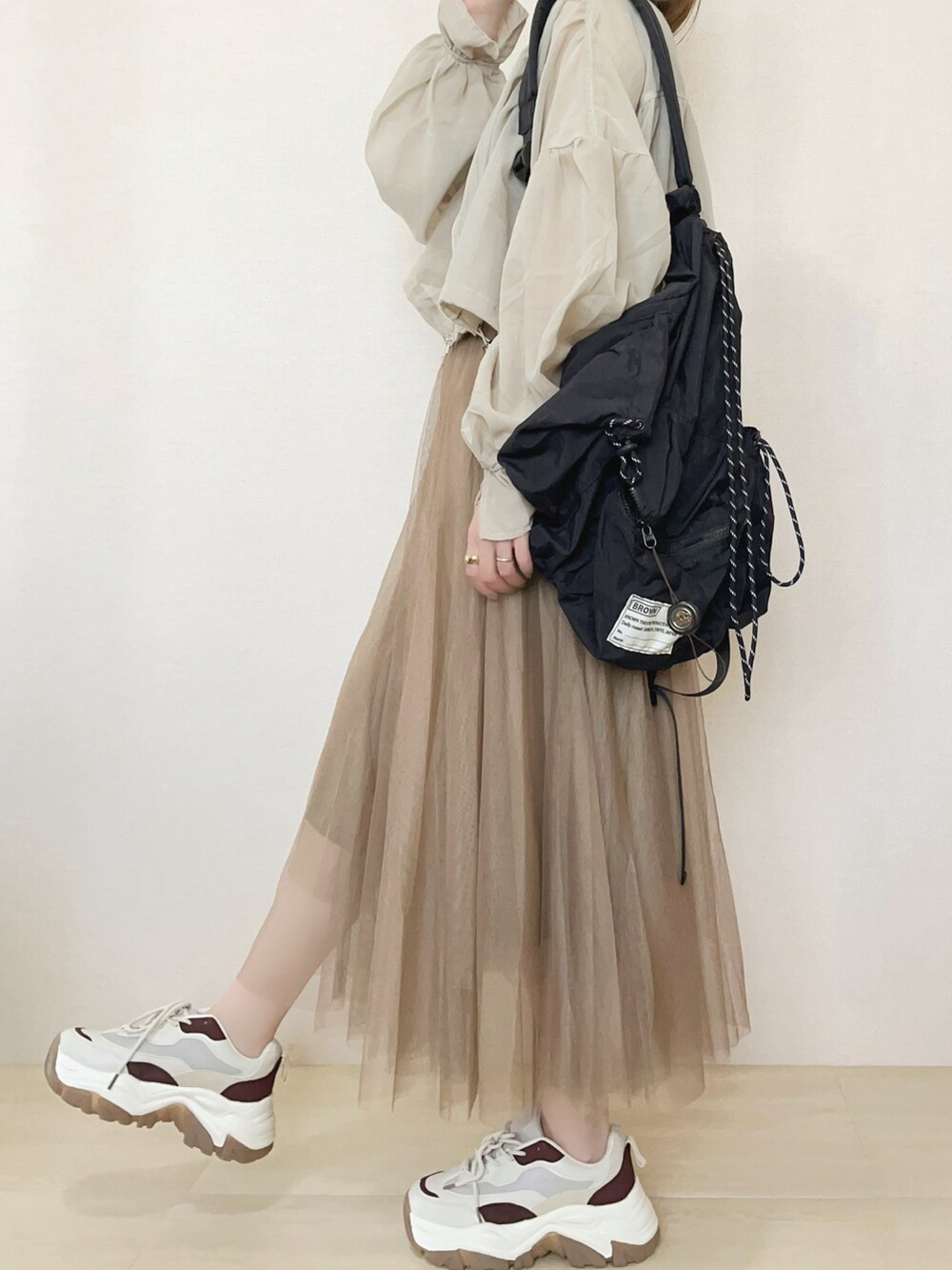 ベージュ系のブルゾン、ブラウン系のスカートを着用したレディースの春コーディネートの3枚目の写真