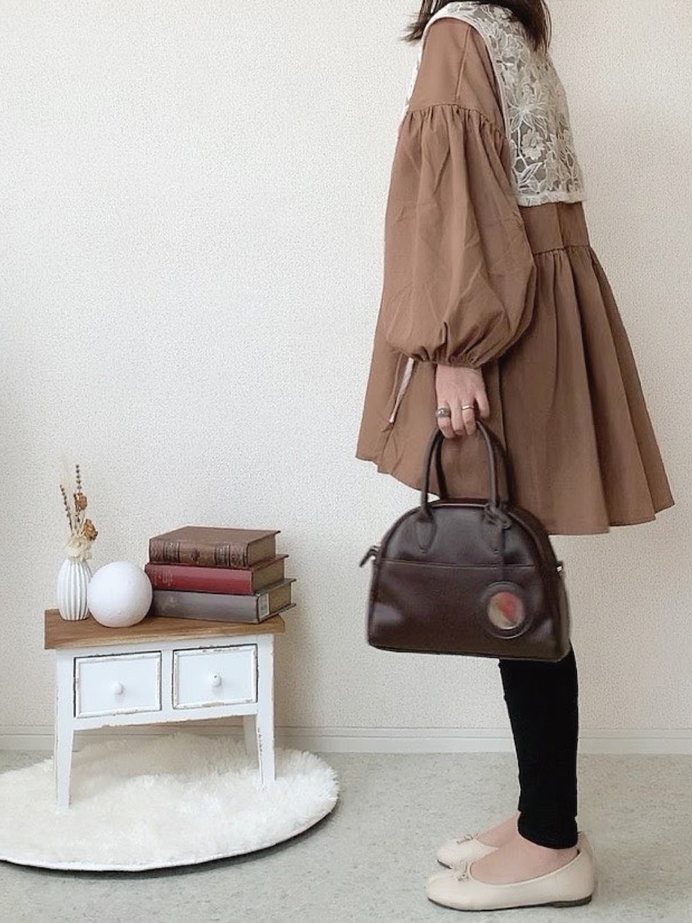 ホワイト系のベスト、ブラック系のデニムパンツ、ホワイト系のバレエシューズを着用したレディースの秋コーディネートの2枚目の写真