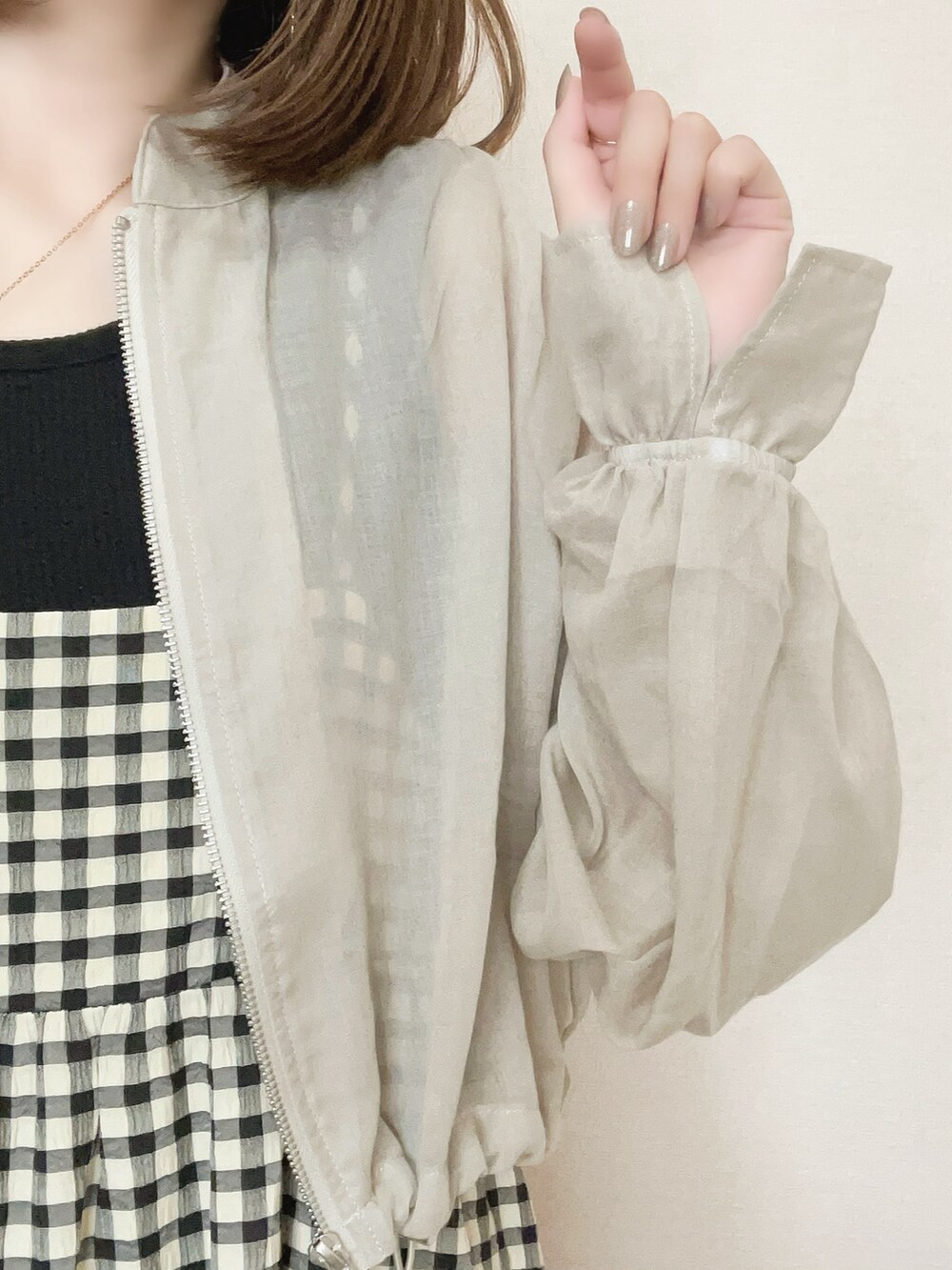 ベージュ系のブルゾン、ブラック系のワンピースを着用したレディースの春コーディネートの5枚目の写真