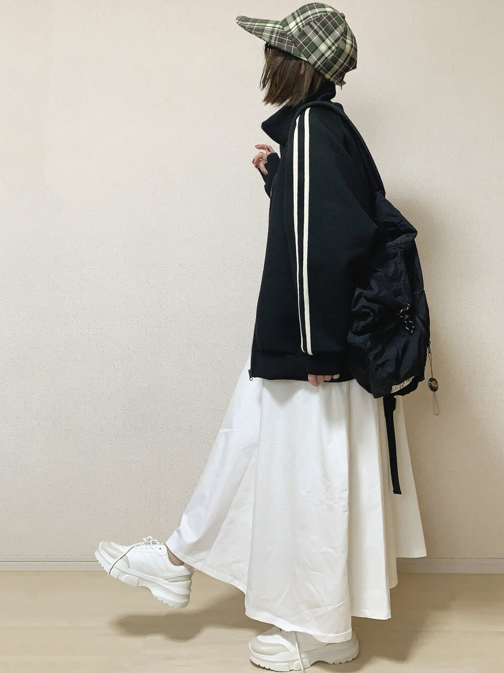 ホワイト系のワンピース、ブラック系のバックパック/リュックを着用したレディースの春コーディネートの2枚目の写真