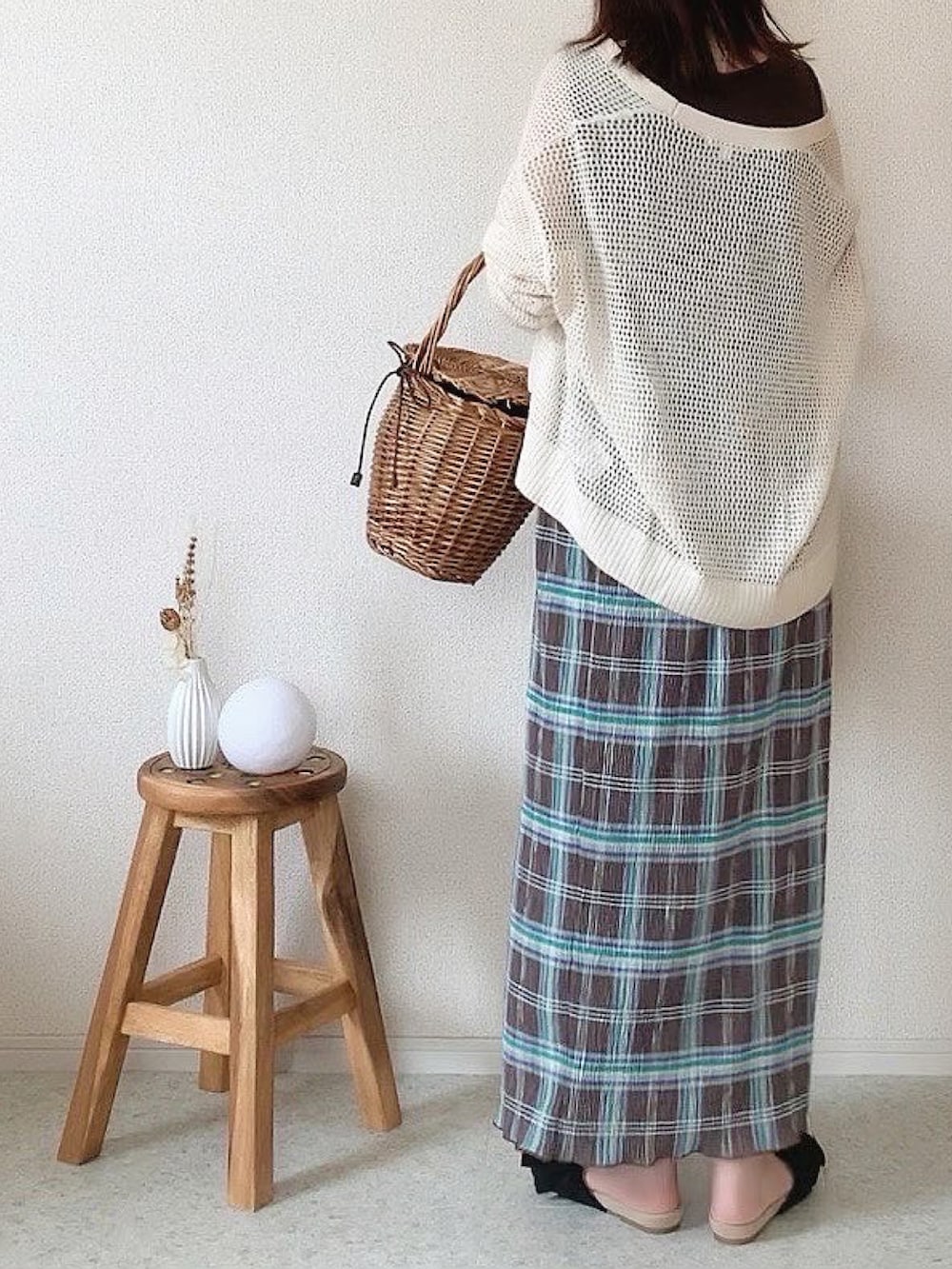 ブラウン系のかごバッグ、ブラウン系のスカート、ゴールド系のネックレスを着用したレディースの夏コーディネートの3枚目の写真