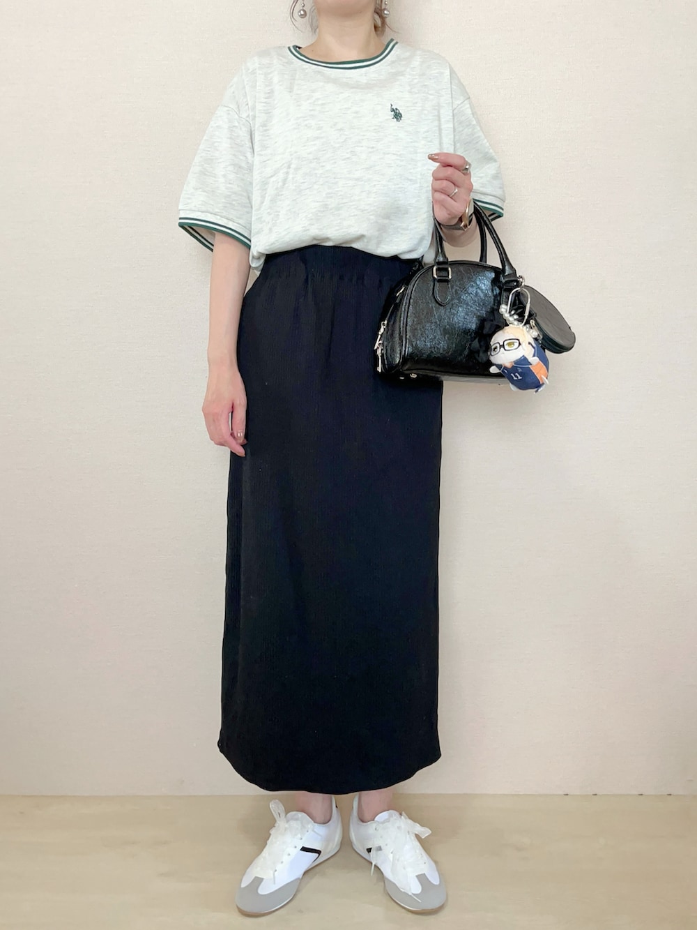 ベージュ系のTシャツ/カットソー、ブラック系のスカートを着用したレディースの春コーディネートの2枚目の写真