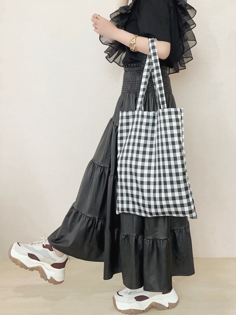 ブラック系のアンサンブル、ブラック系のスカートを着用したレディースの春コーディネートの3枚目の写真