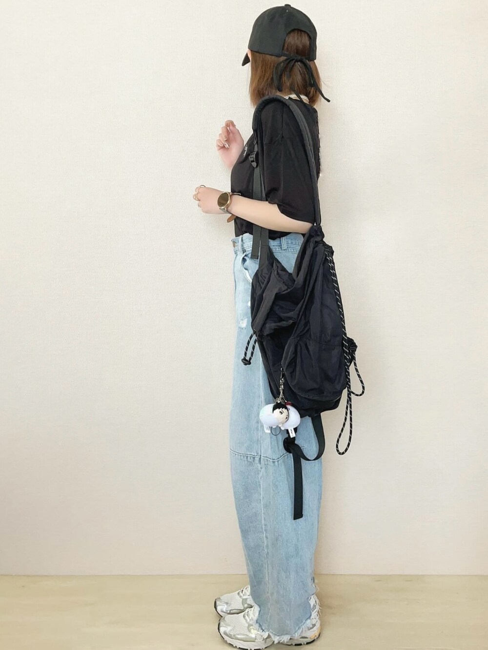 ブラック系のTシャツ/カットソー、ブルー系のデニムパンツを着用したレディースの春コーディネートの3枚目の写真