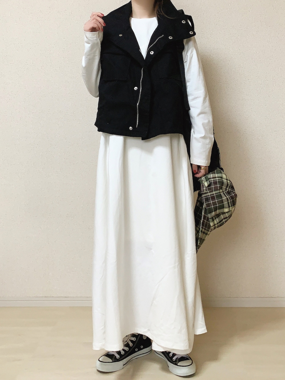 ホワイト系のワンピース、ブラック系のミリタリージャケット、ブラック系のバックパック/リュックを着用したレディースの春コーディネートの2枚目の写真