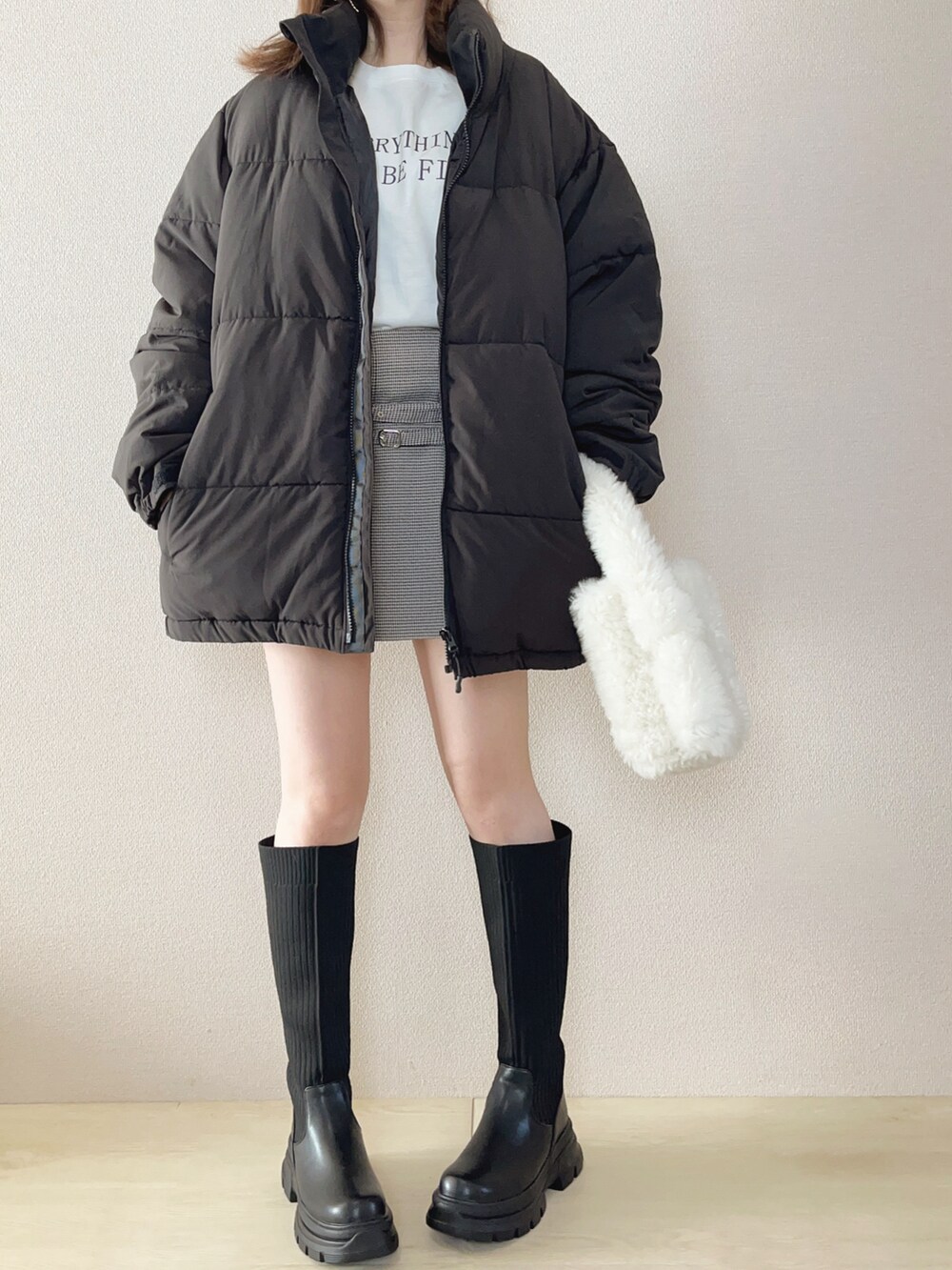 ブラック系のダウンジャケット/コート、ホワイト系のTシャツ/カットソー、ブラック系のブーツを着用したレディースの秋コーディネートの2枚目の写真