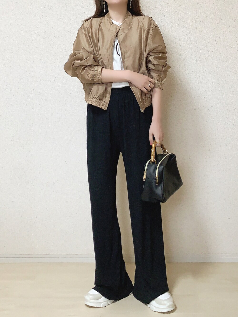 ベージュ系のブルゾン、ブラック系のその他パンツ、その他のTシャツ/カットソーを着用したレディースの春コーディネートの2枚目の写真