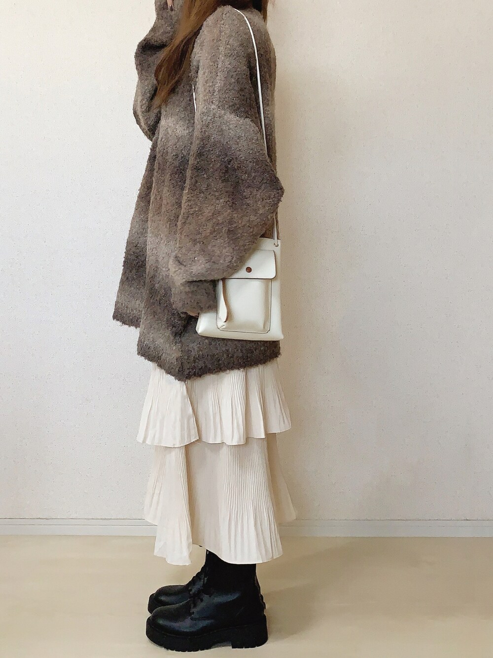 ベージュ系のスカート、ブラウン系のニット/セーターを着用したレディースの秋コーディネートの3枚目の写真