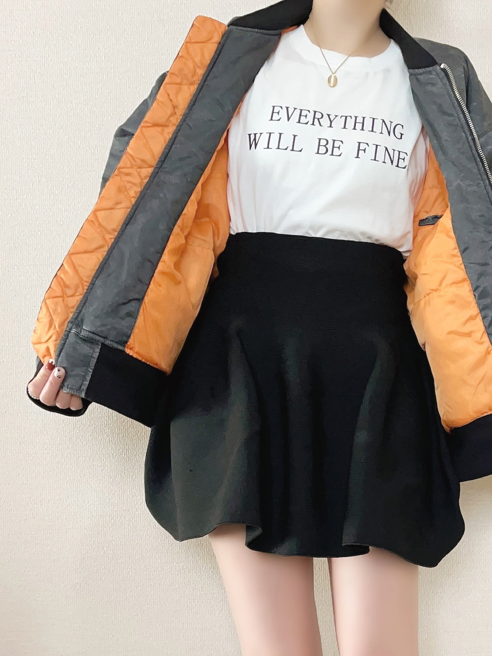 ブラック系のMA-1、ホワイト系のTシャツ/カットソー、ブラック系のスカートを着用したレディースの冬コーディネートの3枚目の写真