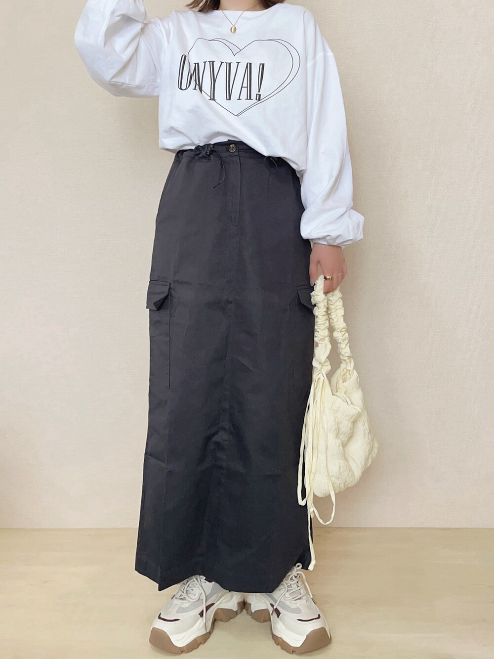 ホワイト系のTシャツ/カットソー、グレー系のスカートを着用したレディースの春コーディネートの2枚目の写真