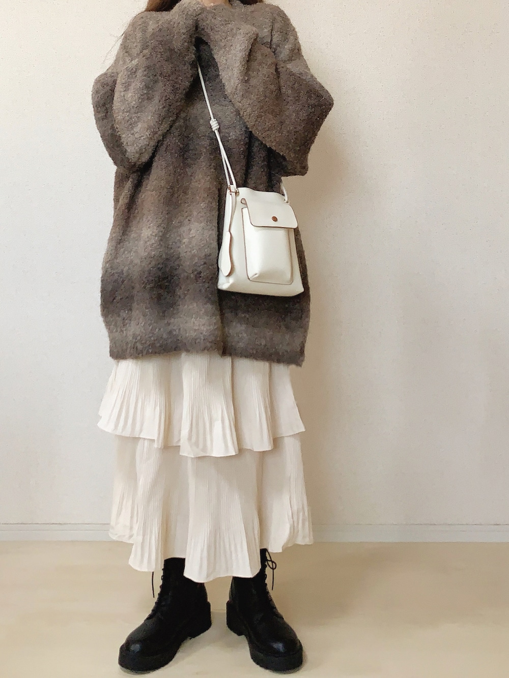 ベージュ系のスカート、ブラウン系のニット/セーターを着用したレディースの秋コーディネートの2枚目の写真