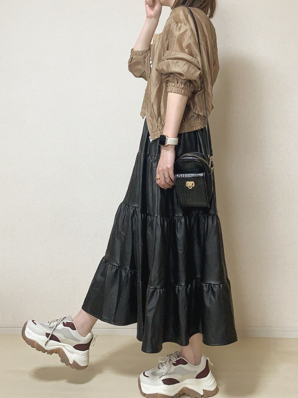 ベージュ系のブルゾン、ブラック系のスカートを着用したレディースの春コーディネートの2枚目の写真