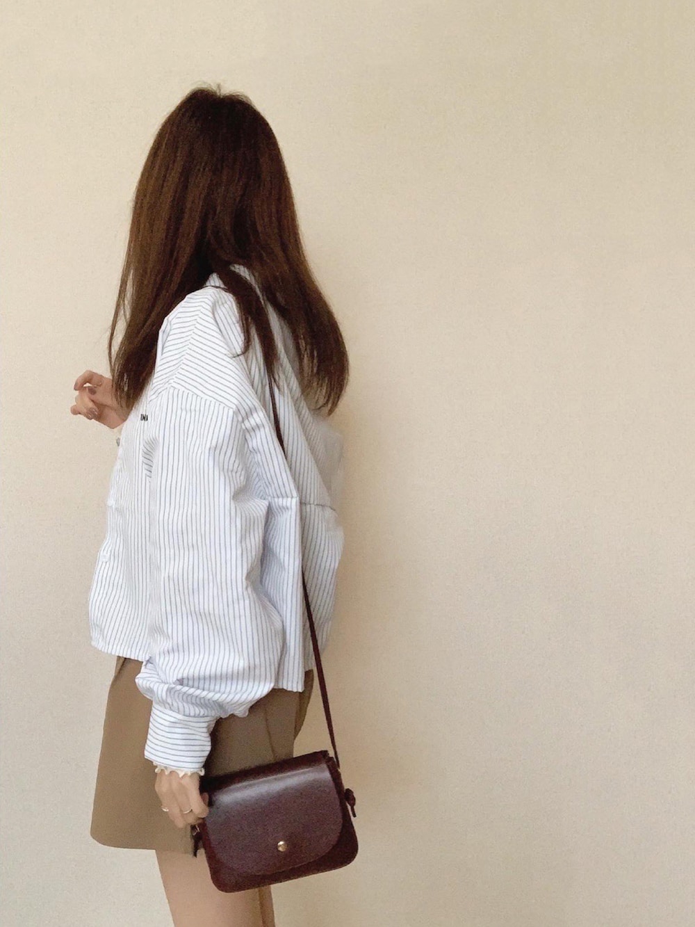 ベージュ系のその他パンツ、ブラウン系のショルダーバッグ、ホワイト系のTシャツ/カットソーを着用したレディースの春コーディネートの3枚目の写真