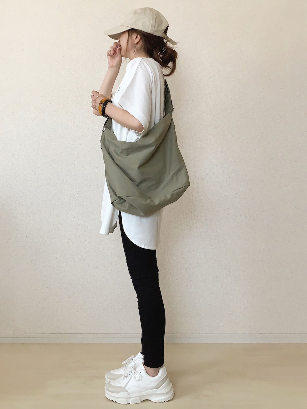 ホワイト系のTシャツ/カットソー、グリーン系のショルダーバッグ、ブラック系のデニムパンツを着用したレディースの夏コーディネートの2枚目の写真